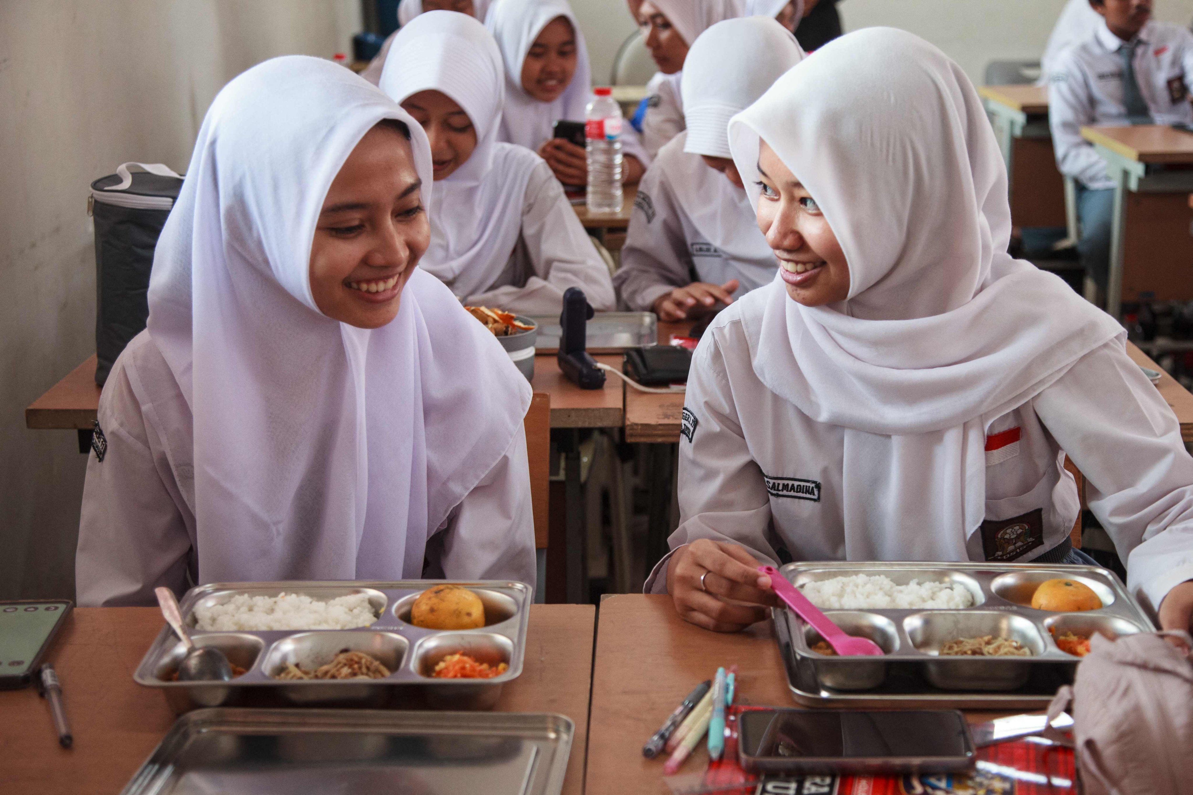 Students receive their lunches  on the first day of a free-meal programme at a high school in East Jakarta on Monday. Photo: AFP