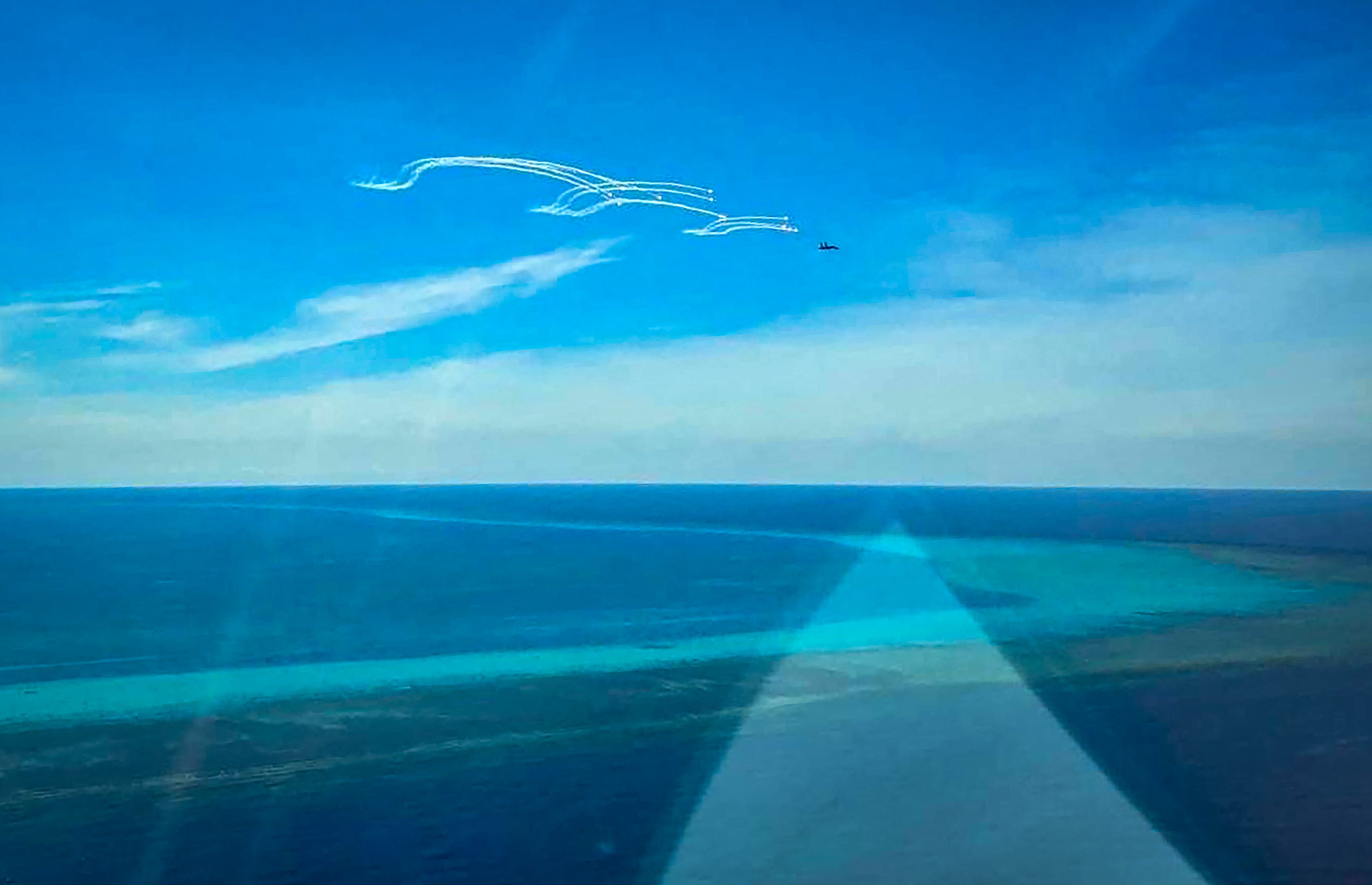 A Chinese fighter jet deploys flares near a Philippine fisheries bureau plane, close to the disputed Scarborough Shoal in the South China Sea in August. Photo: AFP