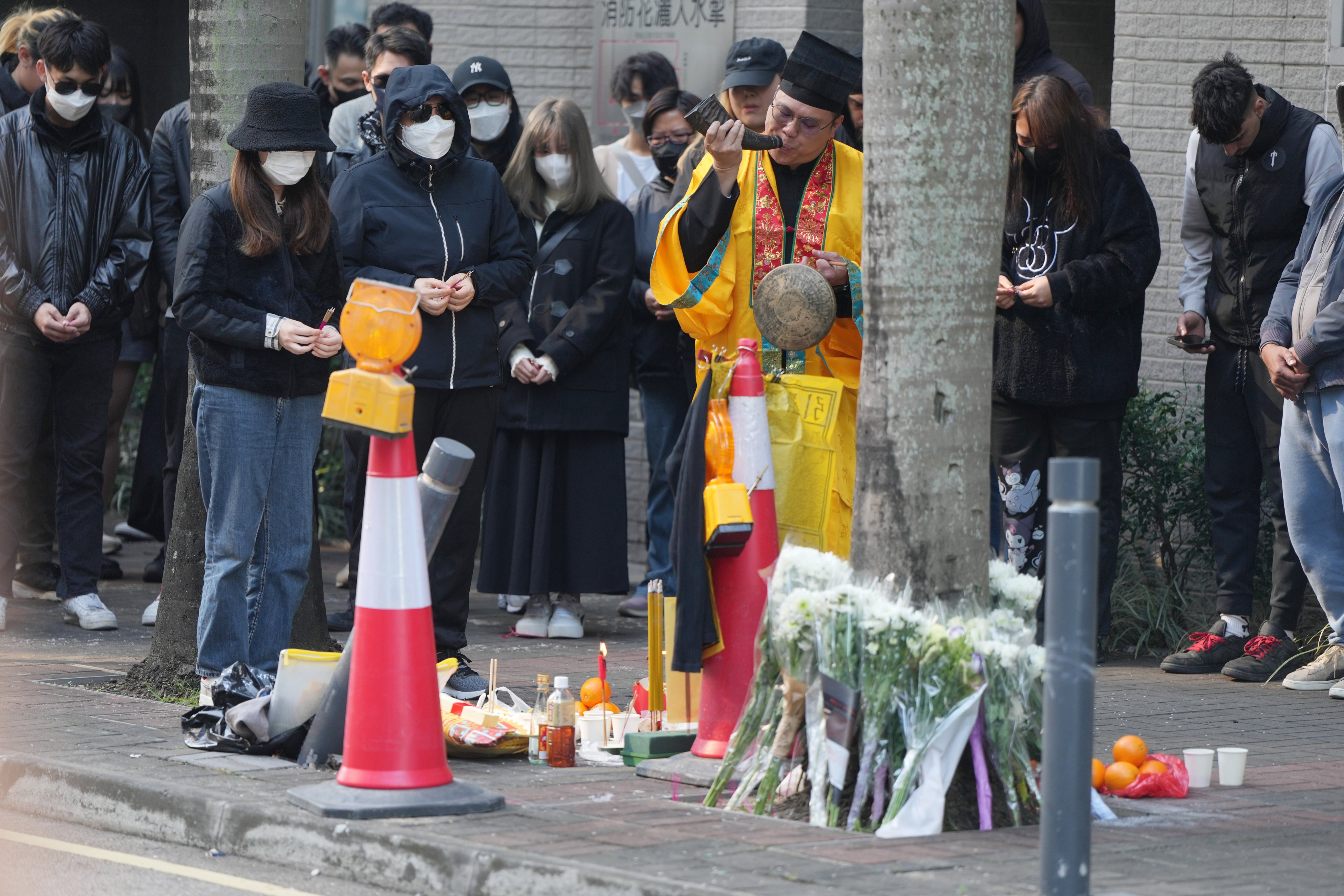 Family members and friends attend a roadside memorial for the motorcyclist who died last Friday in a crash while allegedly fleeing police. Photo: Sam Tsang