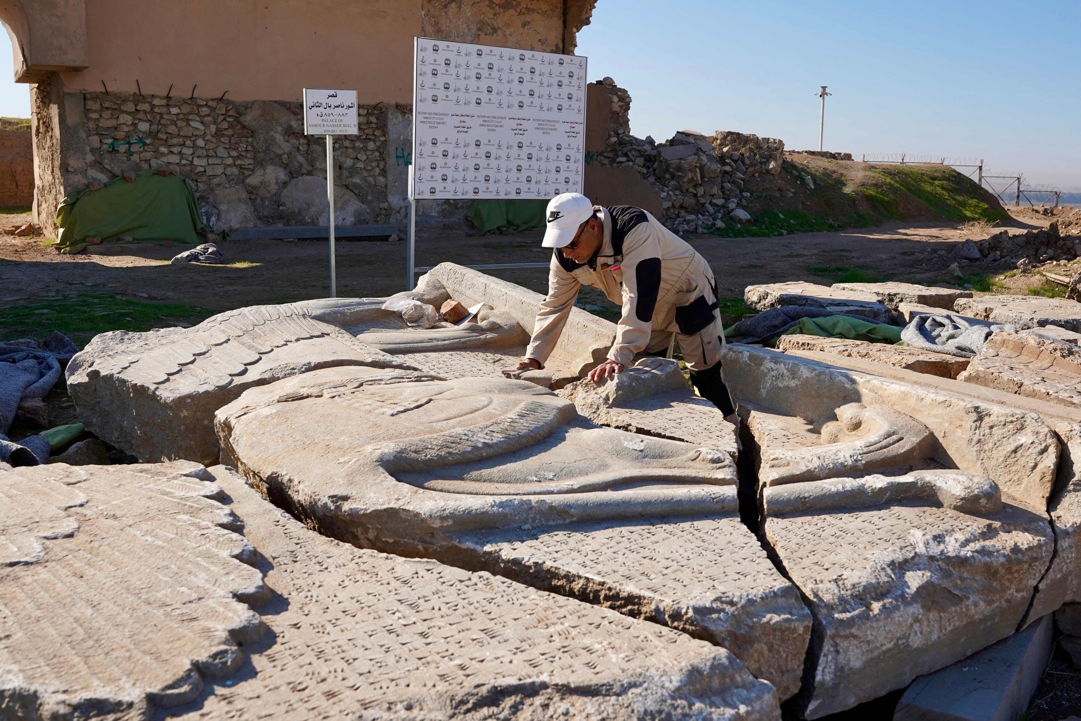 An archaeology expert catalogues destroyed artefacts - which range from bas-reliefs and sculptures to decorated slabs depicting mythical creatures - at the archaeological site of Nimrud, south of Mosul, Iraq, on January 3, 2025. Photo: AFP