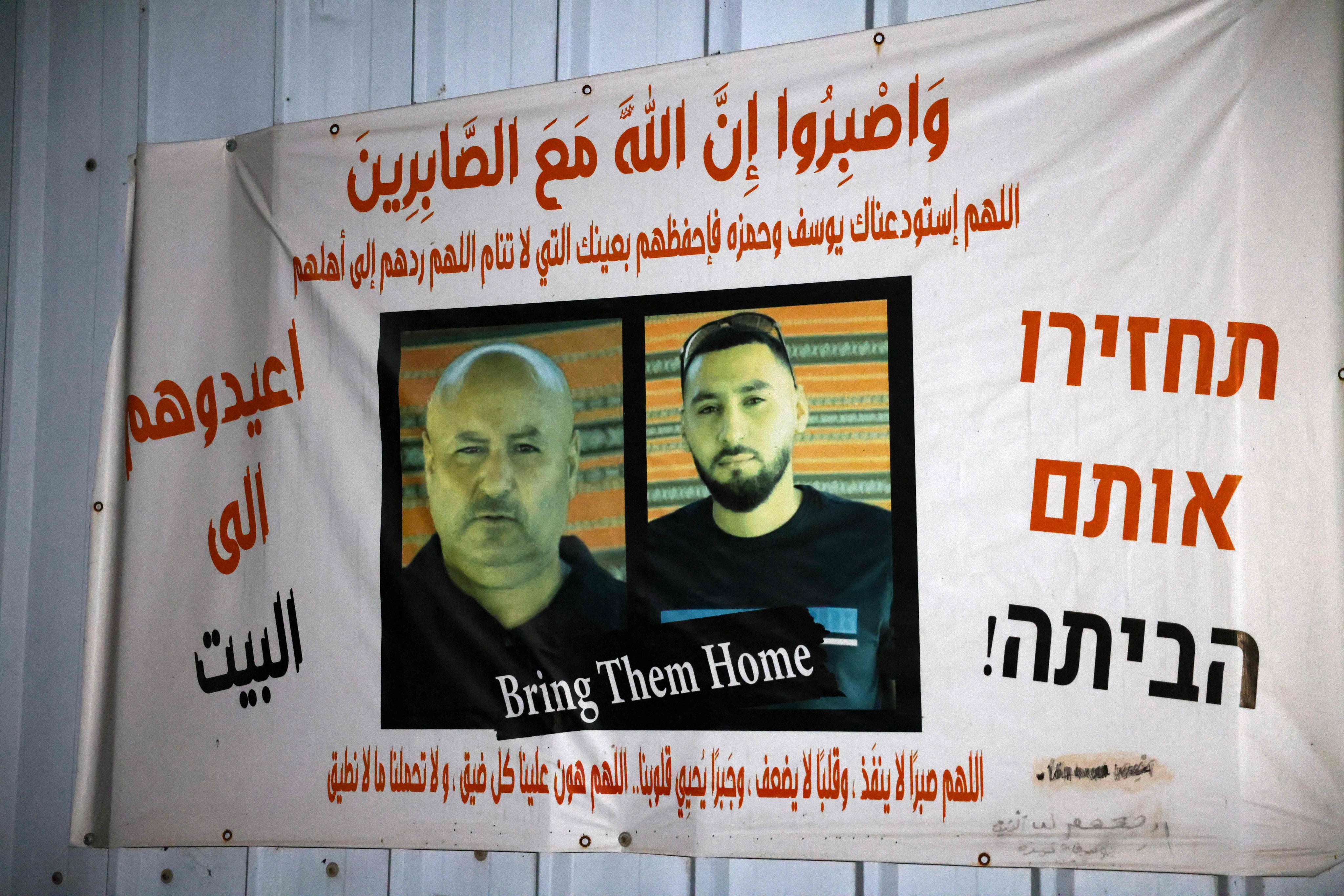 A banner bearing pictures of Bedouin Arab hostages Youssef al-Zayadna and his son Hamza, at the gate of the family home. Photo: AFP