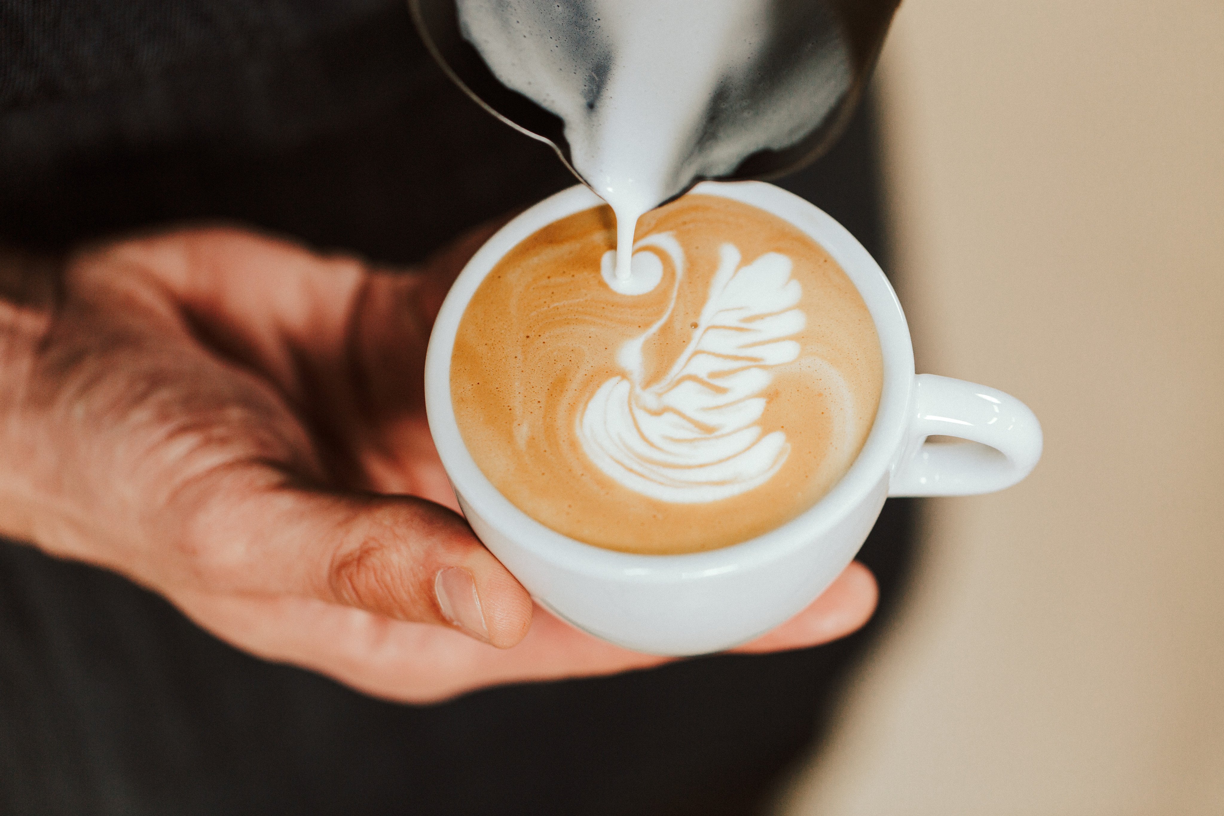 A barista pours a freshly made coffee. Photo: Shutterstock