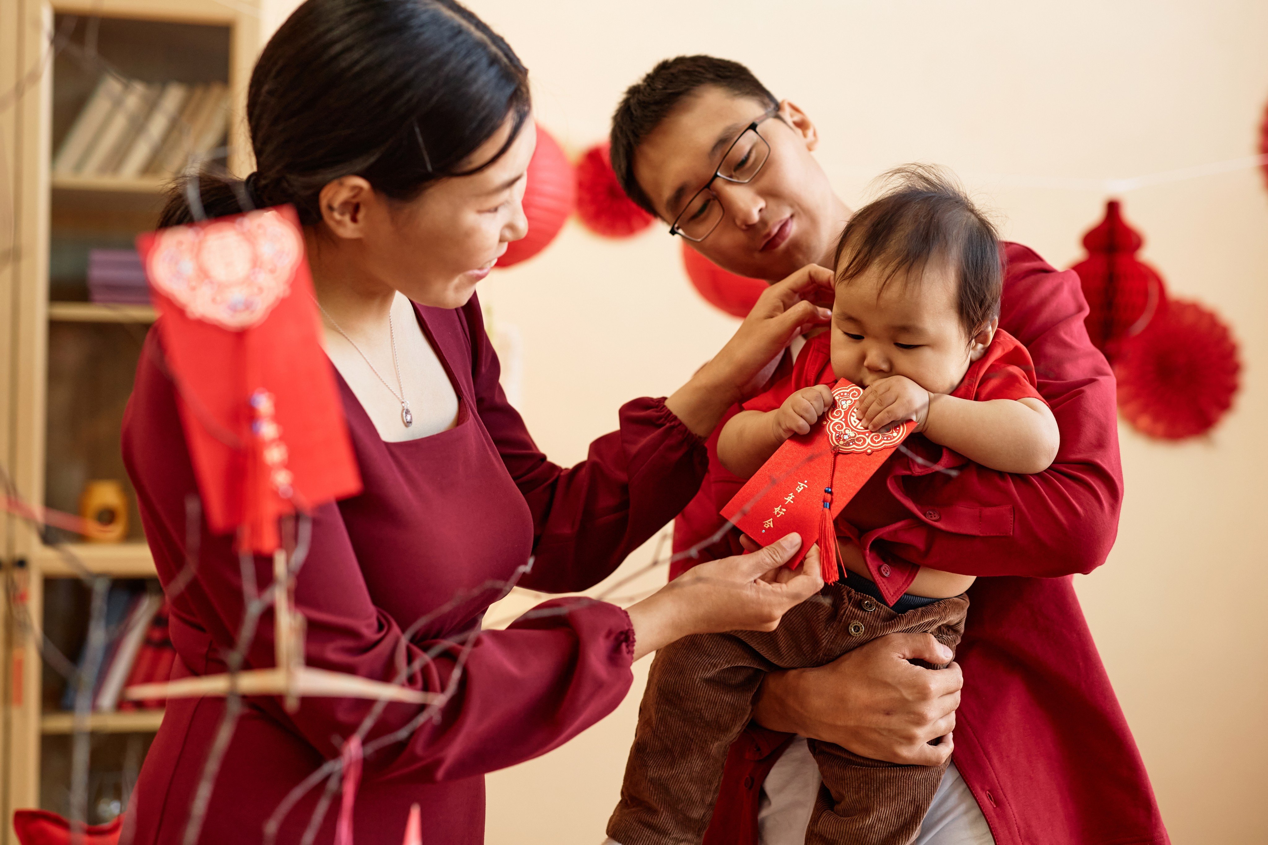 A family where the lucky colour red for Lunar New Year. Fewer babies are born in the Year of the Snake, with many parents believing they will be unlucky. Photo: Shutterstock