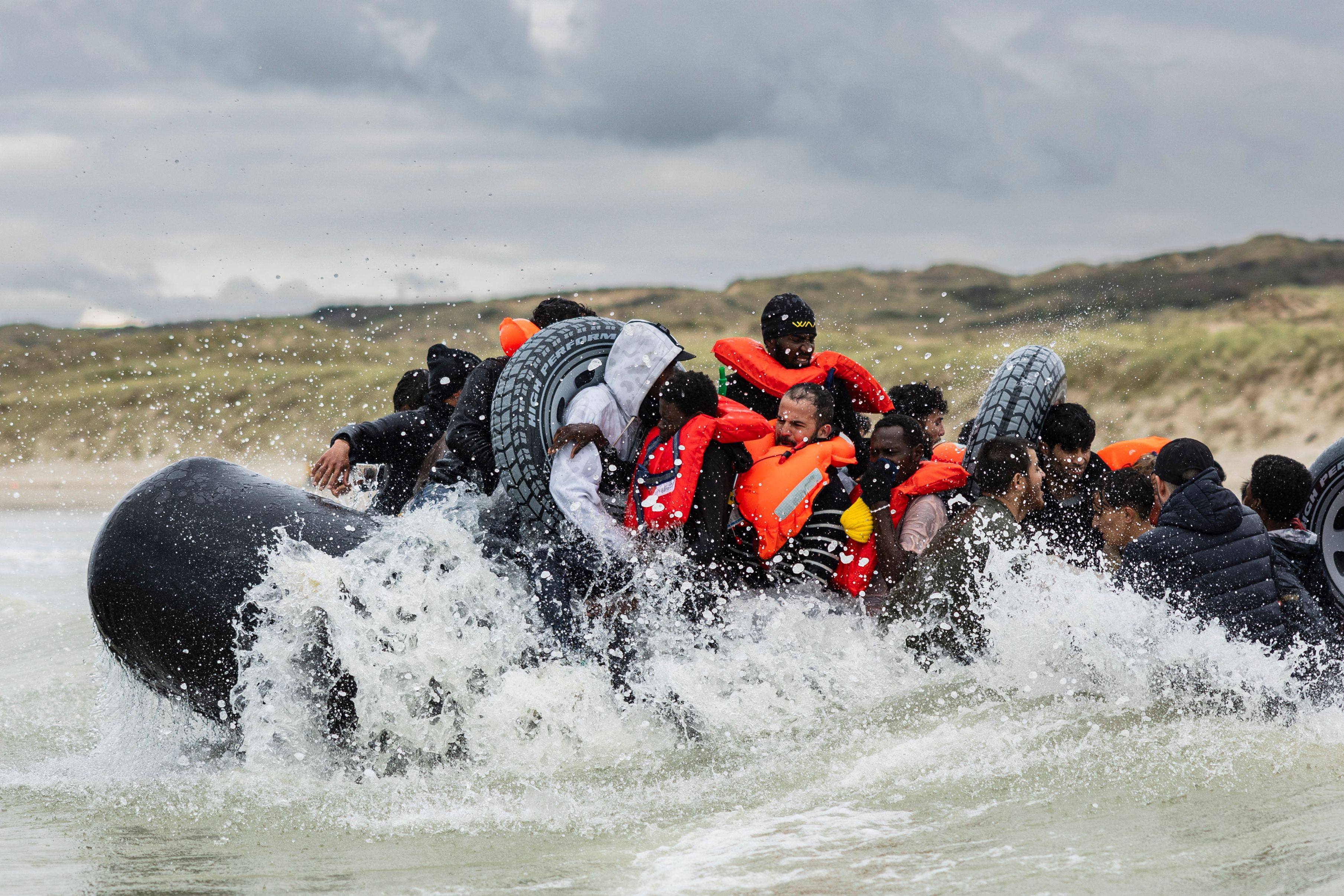 Migrants board a smuggler’s inflatable dinghy in an attempt to cross the English Channel. Photo: AFP