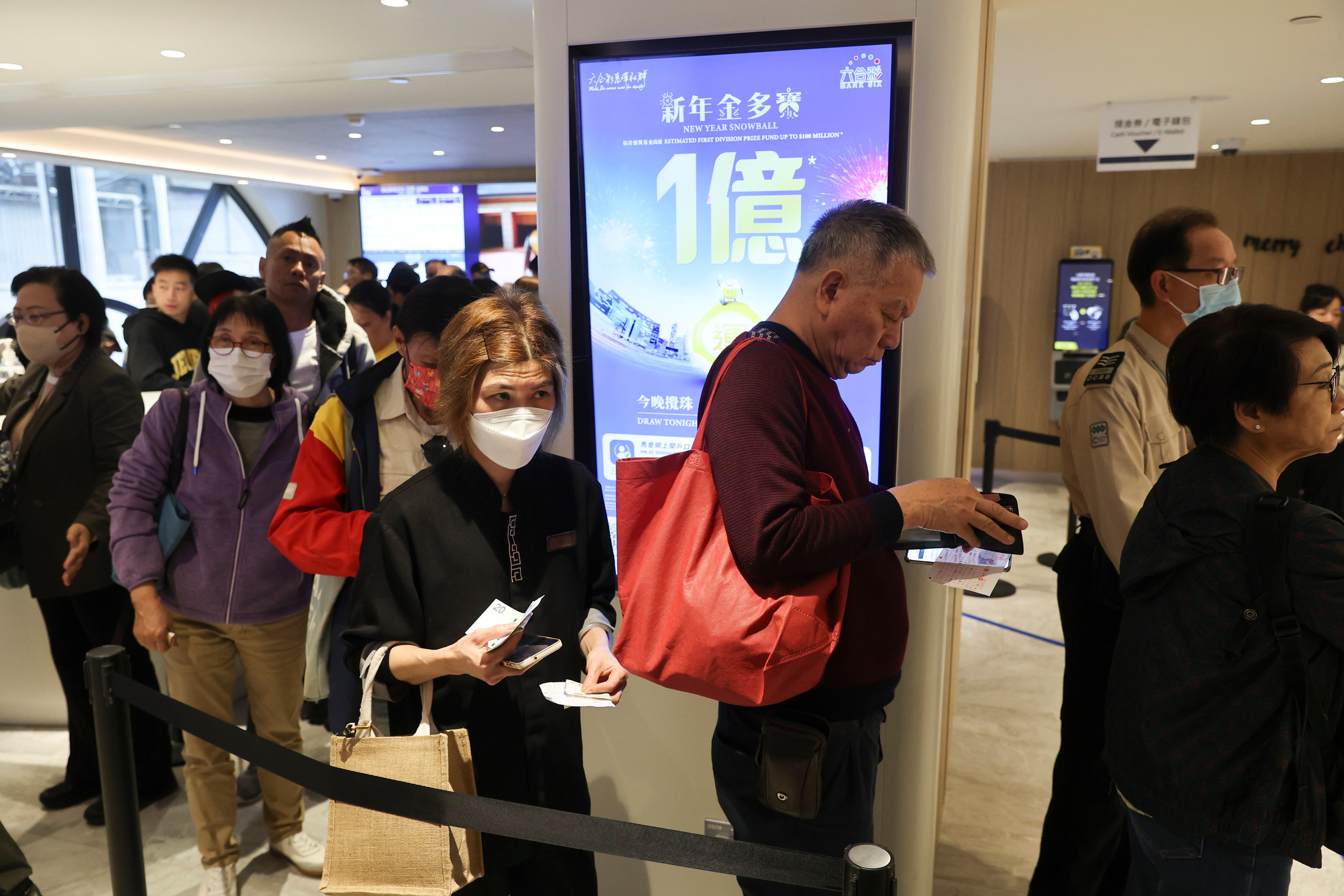 People queue to buy lottery tickets at a branch of the Hong Kong Jockey Club in the city’s Central business district for the Mark Six Snowball draw of HK$100 million on January 2, 2025. Photo: Edmond So