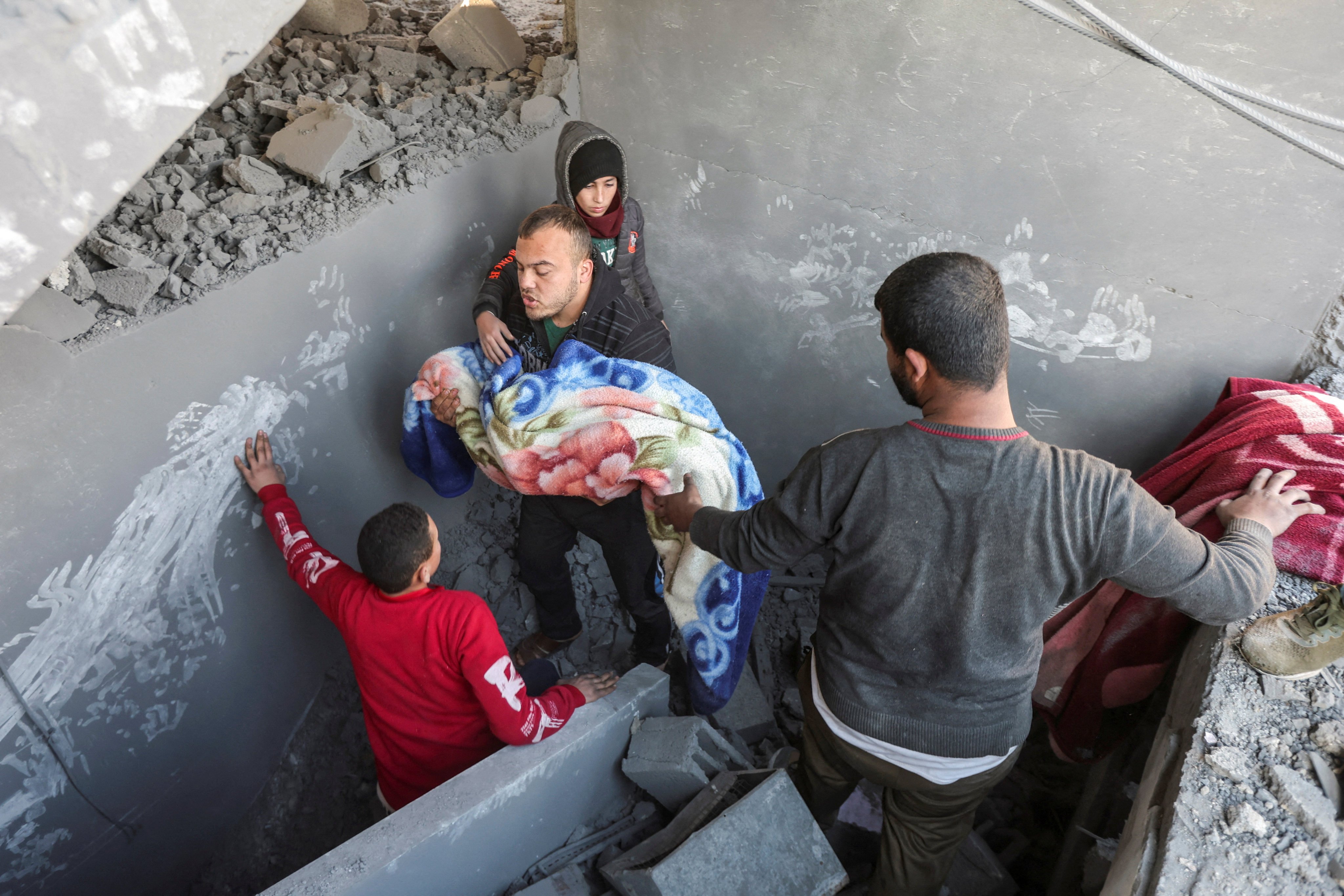 Palestinians carry the body of a child at the site of an Israeli strike on a house in Nuseirat, in the central Gaza Strip. Photo: Reuters