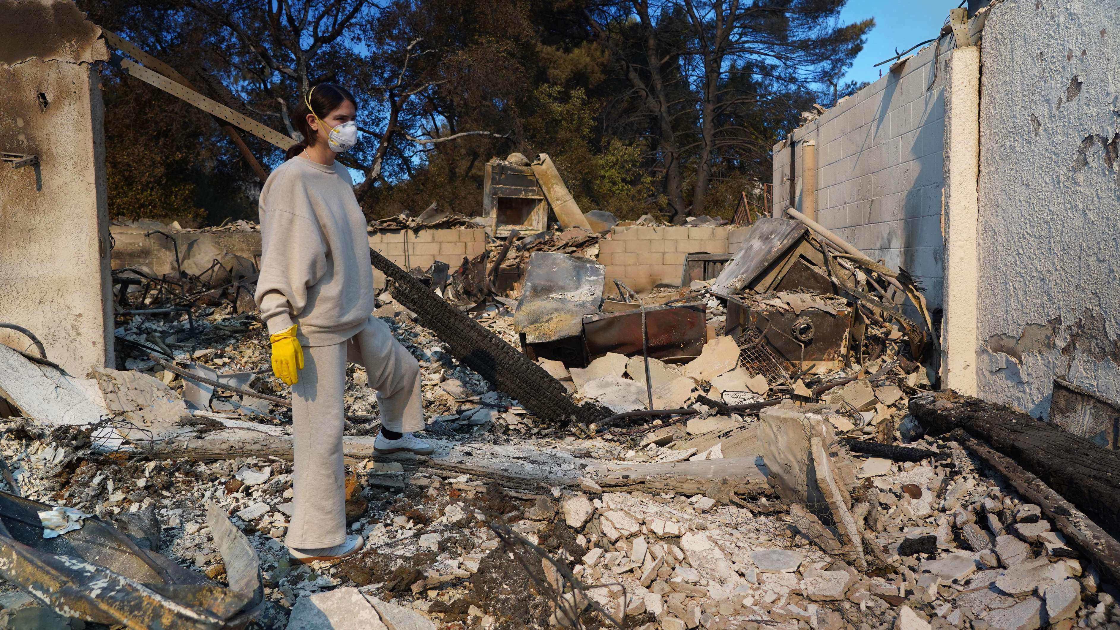 Nicole Perri looks for belongings in the ruins of her house destroyed by the fire in the Pacific Palisades neighbourhood of Los Angeles on January 10. Photo: AFP