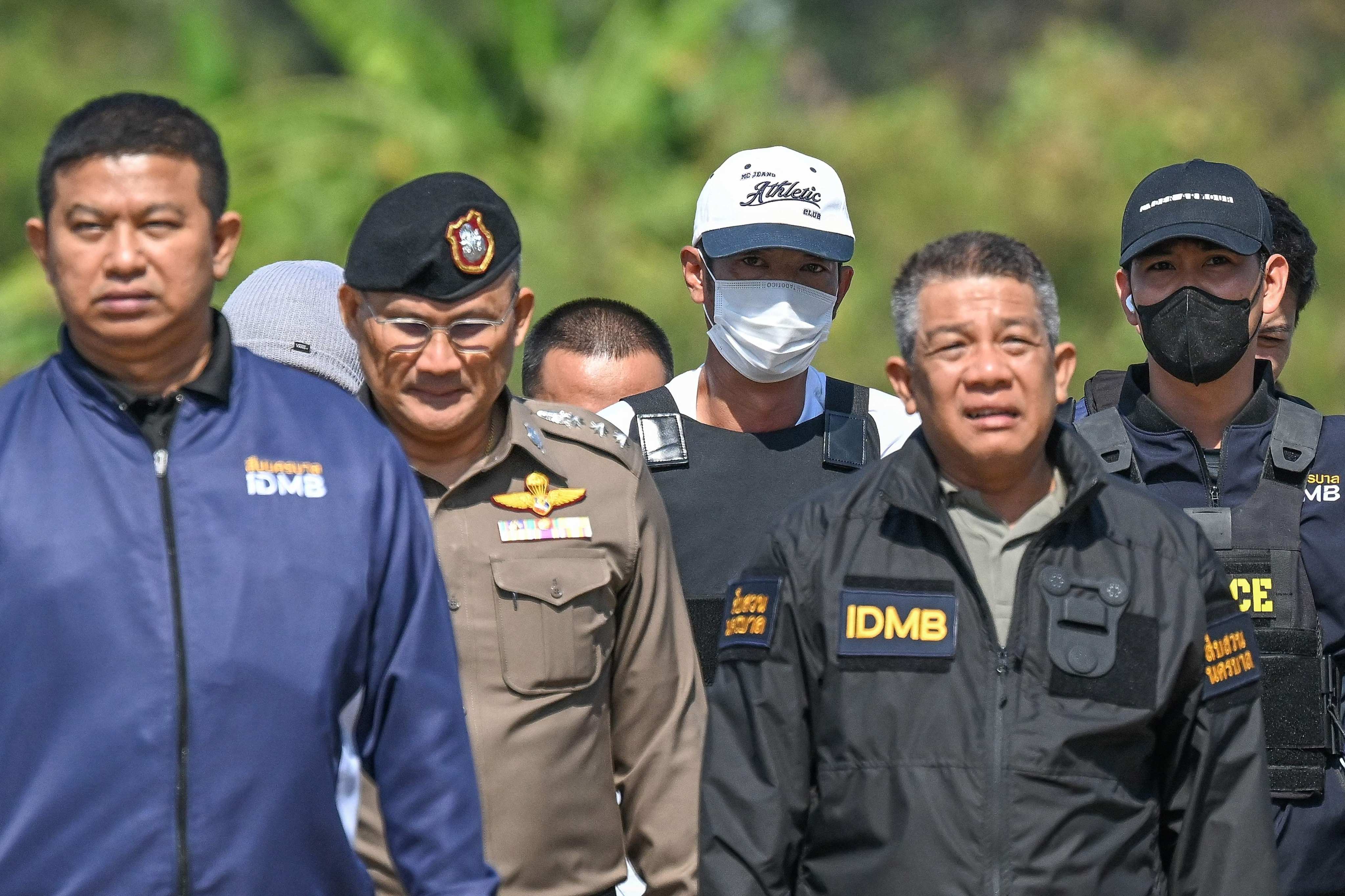 Thai national Ekalak Paenoi (centre) is escorted by police officers at the police airport in Bangkok on Saturday. Photo: AFP