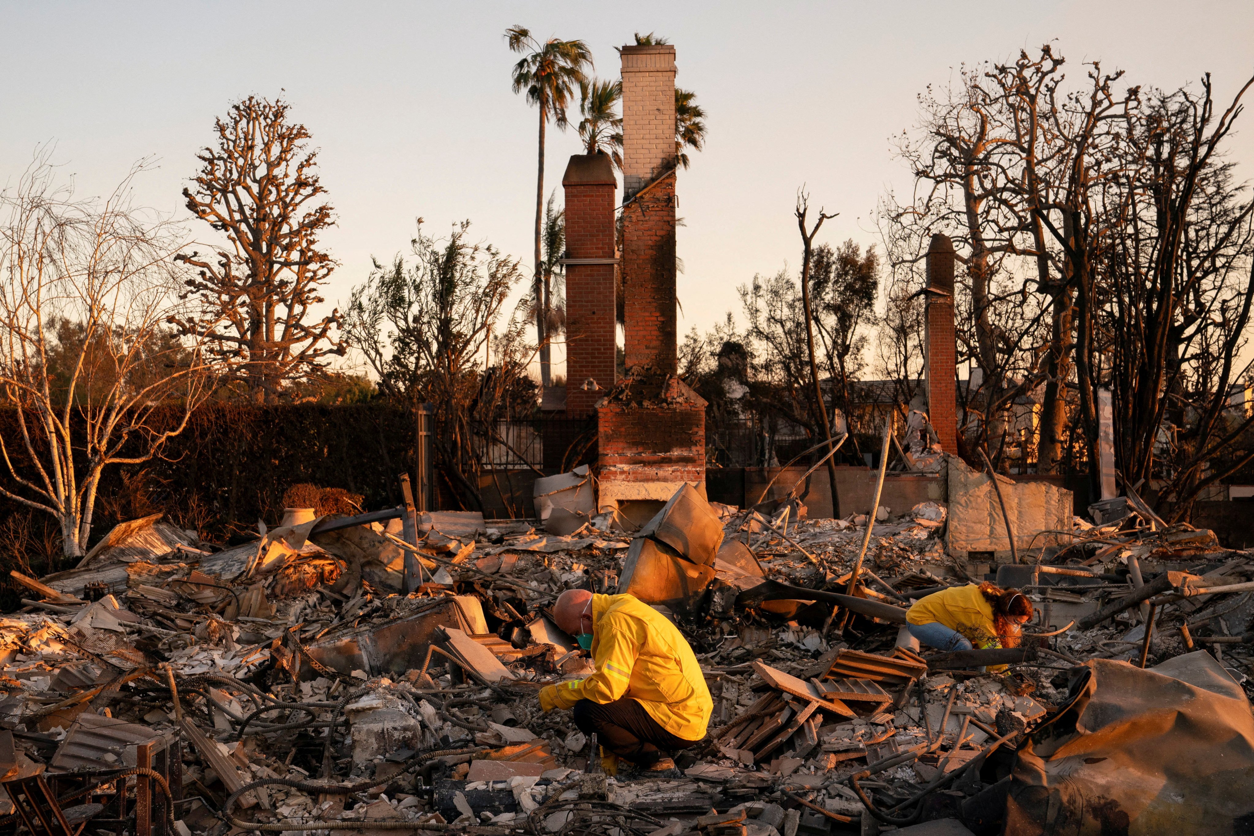 Pacific Palisades residents look through the remains of their home, which was destroyed by fire. Photo: Reuters