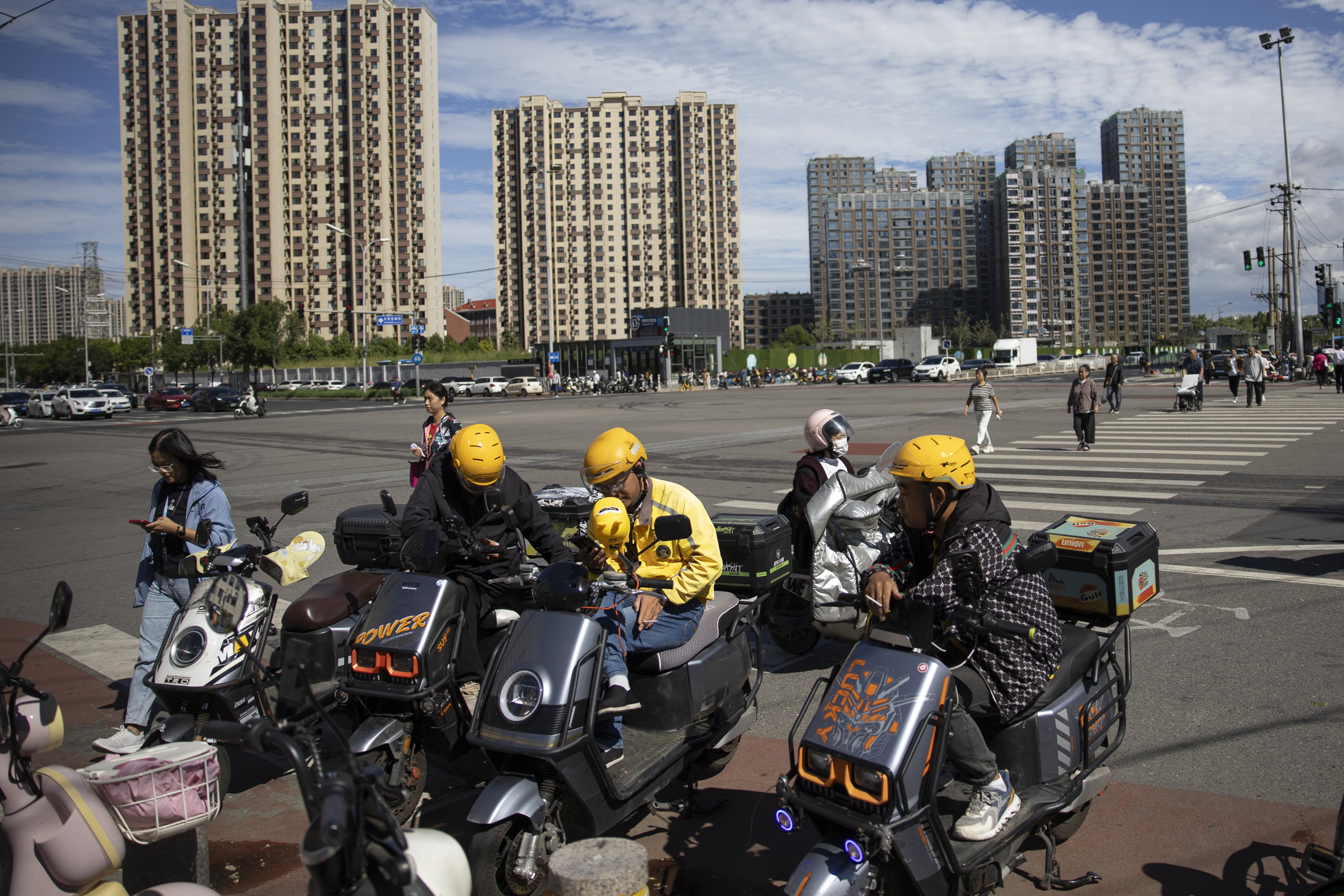 Delivery drivers sit on electric scooters in Beijing on September 14, 2024. Photo: EPA-EFE