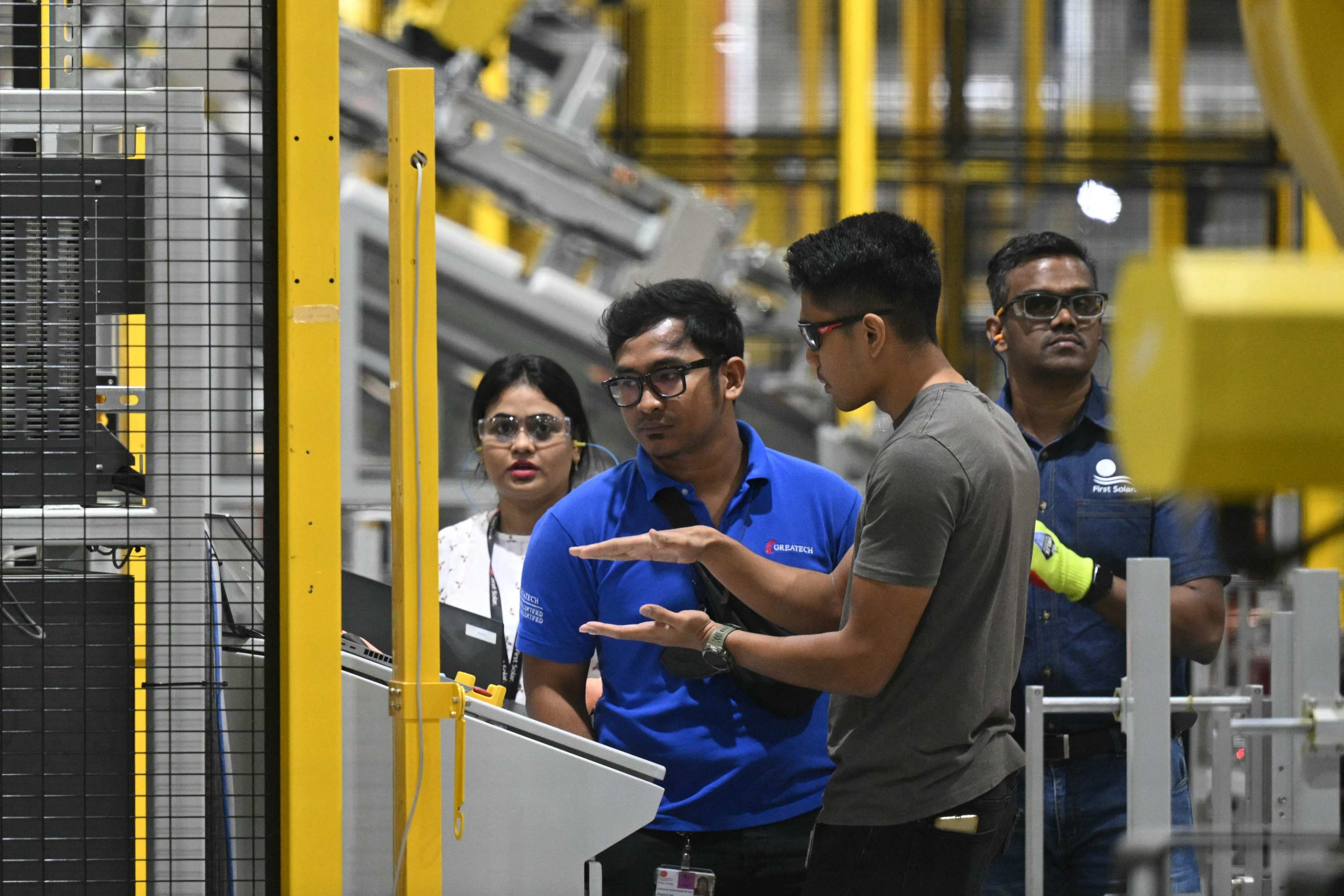 Workers operate a machine at a manufacturing facility in Kanchipuram district in India. Photo: AFP