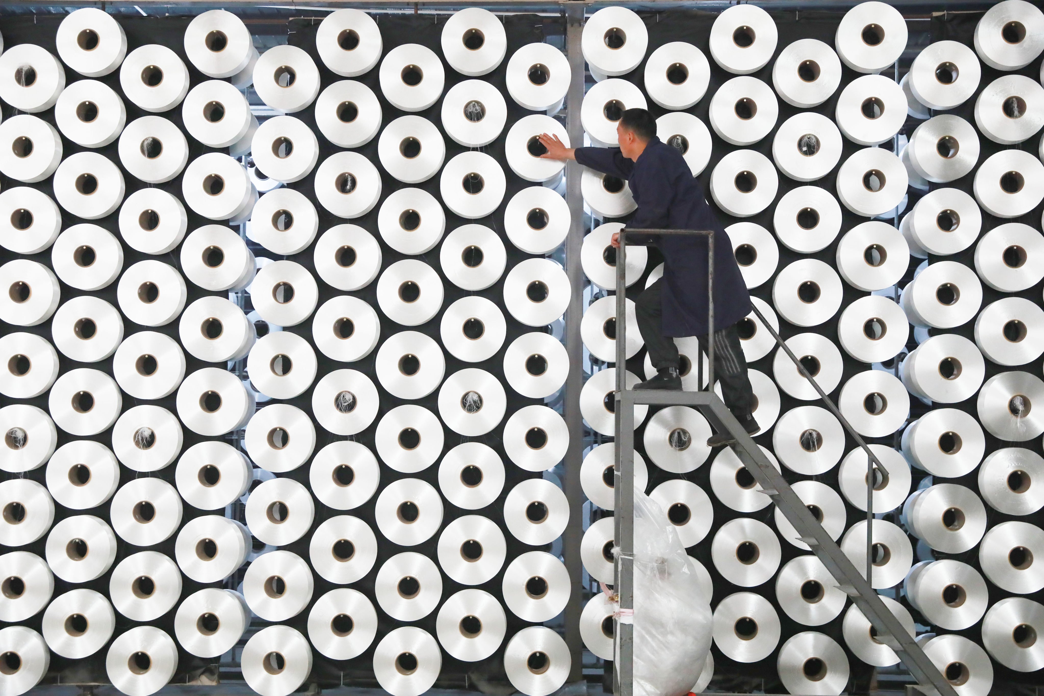 A worker handles a spinning machine at a textile factory in China’s Zhejiang province. Photo: Getty Images