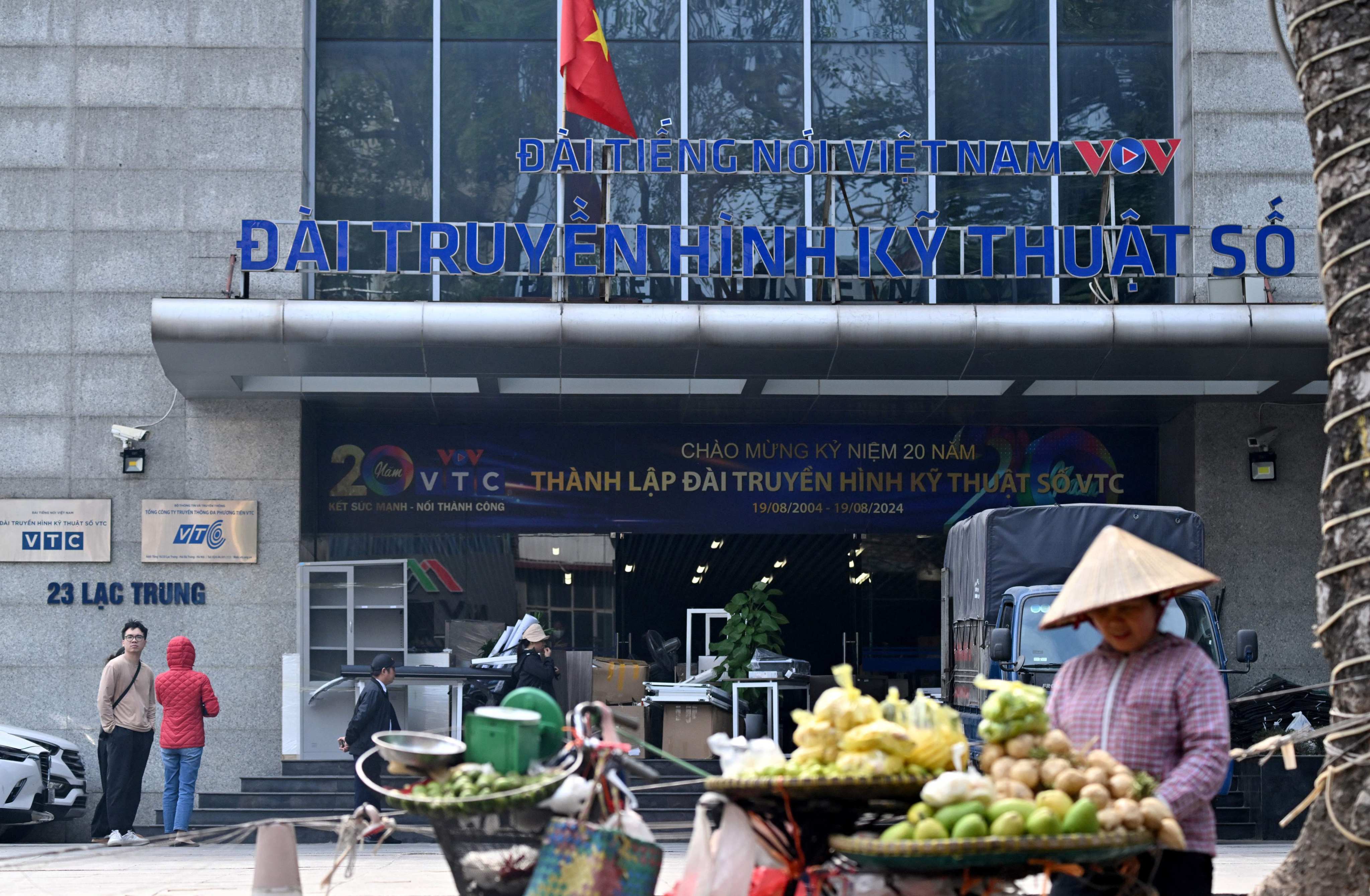 A fruit vendor waits for customers in front of the VTC office building in Hanoi on Wednesday. Photo: AFP