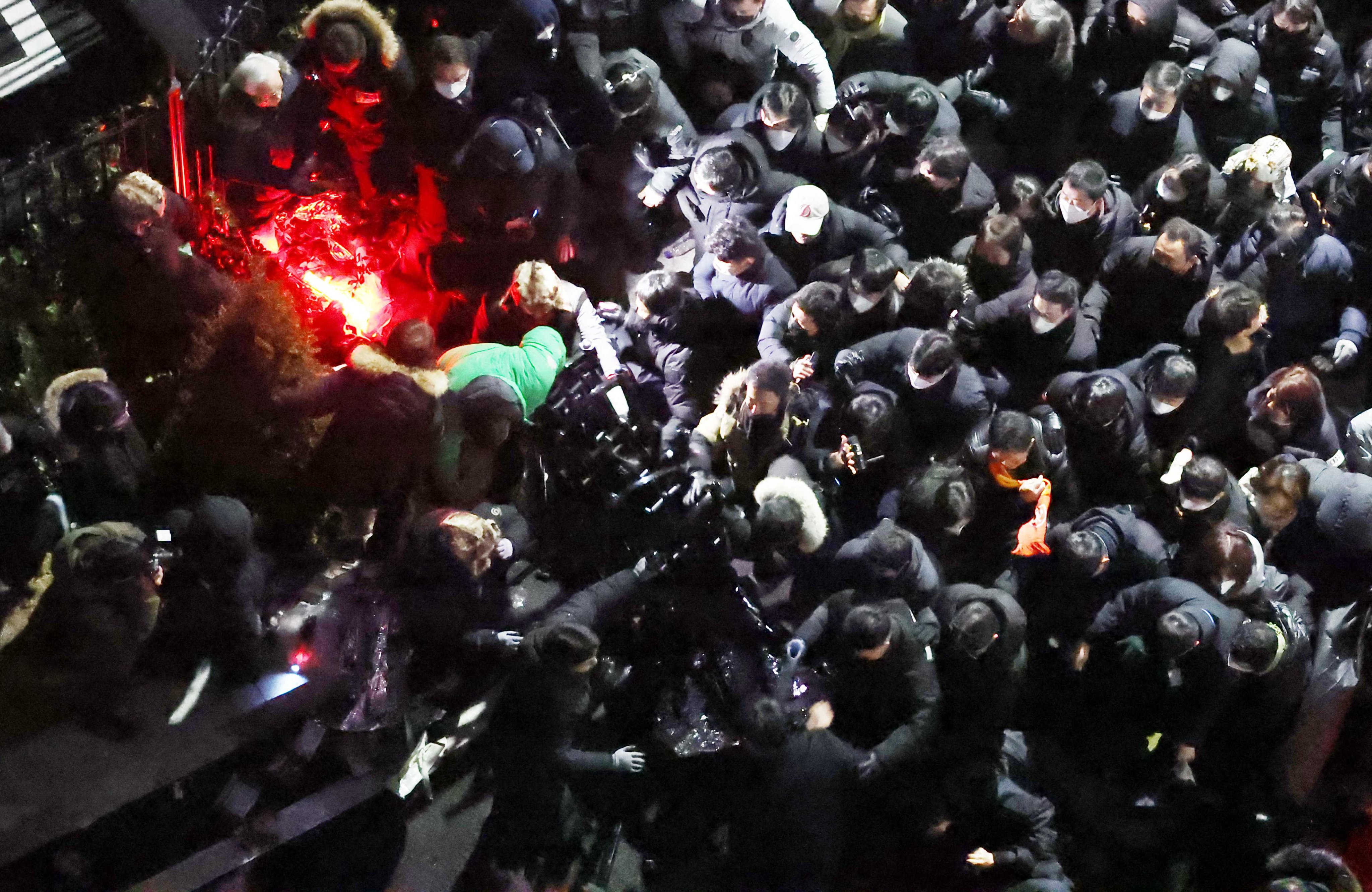 Officials and police officers break through the barricades to enter the presidential residence in Seoul on January 15, 2025 to execute the second arrest warrant for South Korean impeached president Yoon Suk-yeol. Photo by Yonhap/AFP