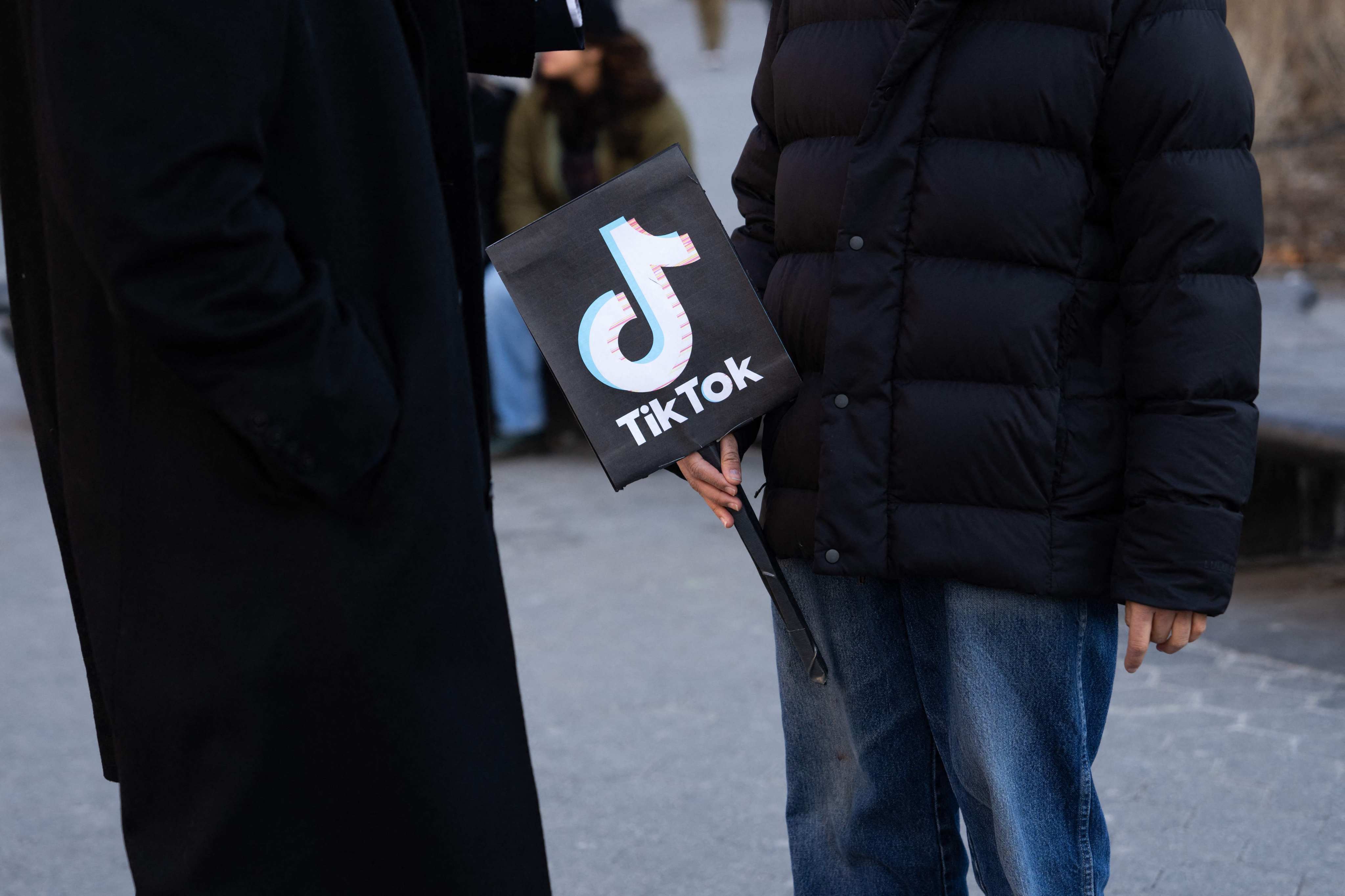 A person holds a TikTok sign in New York City’s Washington Square Park on January 14.TikTok could face a ban on January 19 due to a law requiring the platform to sever ties with its China-based parent company ByteDance, or cease its US operations.  Photo: AFP