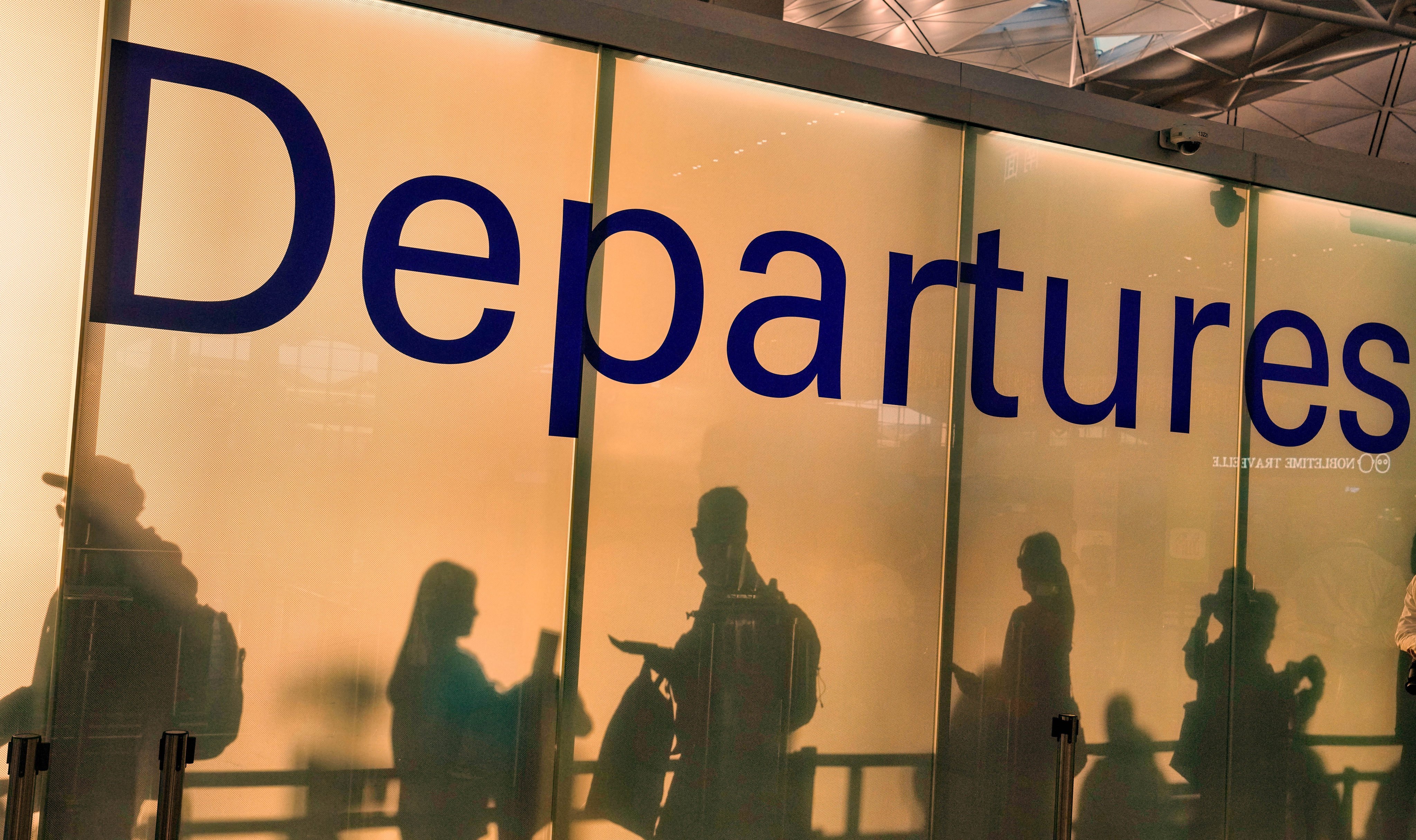 The shadows of travellers are projected on the wall of the departure hall in Hong Kong International Airport. Photo: Elson Li