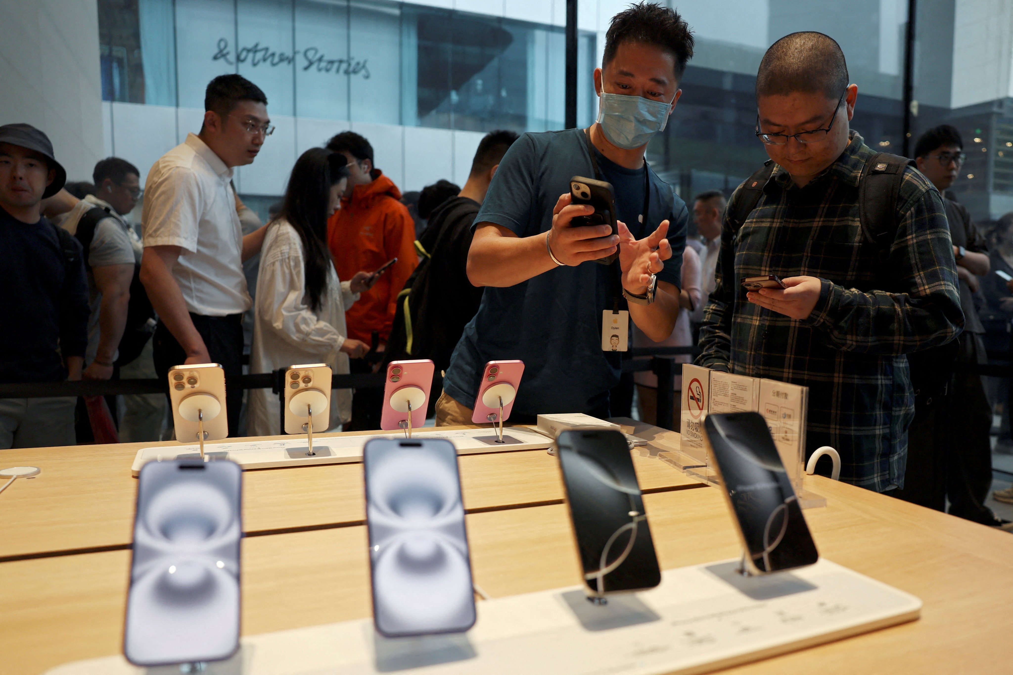 An Apple Store staff member attends to a customer as the new iPhone 16 series smartphones go on sale in Beijing on September 20, 2024. Photo: Reuters