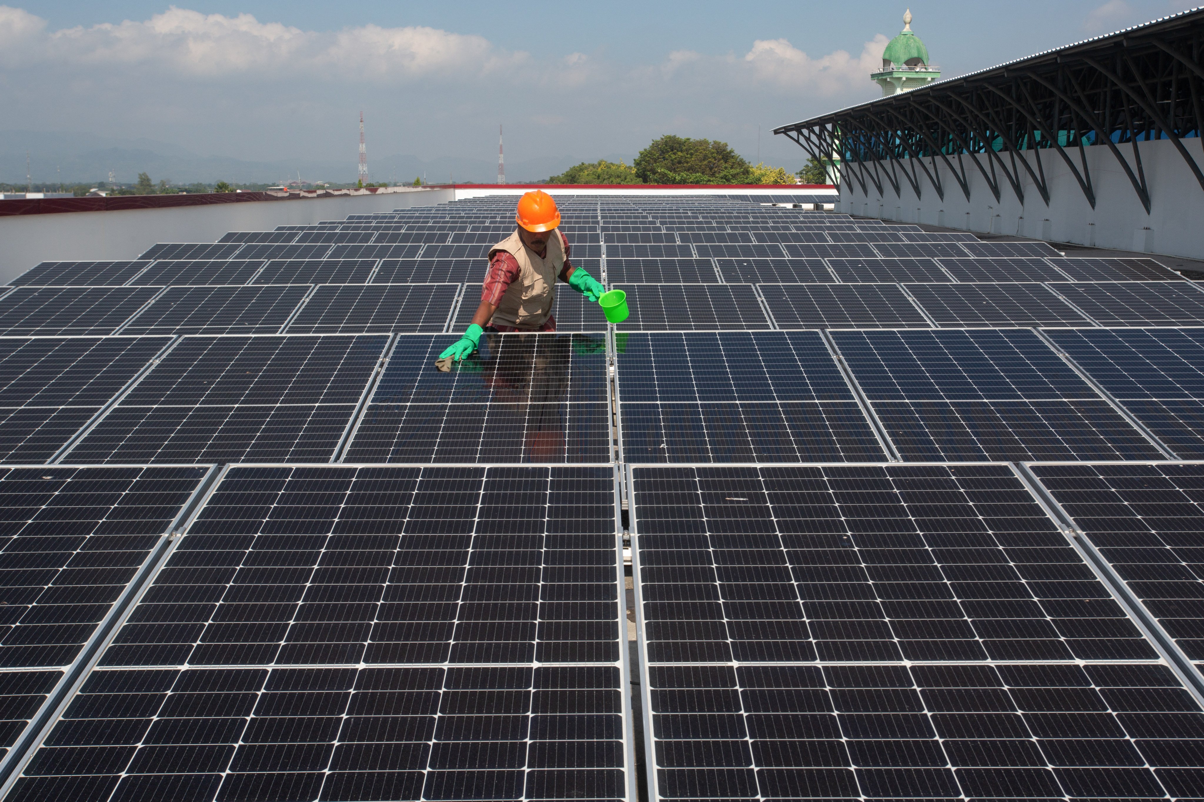 A worker cleans solar panels installed on the roof of a traditional market in Klaten, Central Java, Indonesia, last year. Photo: AFP