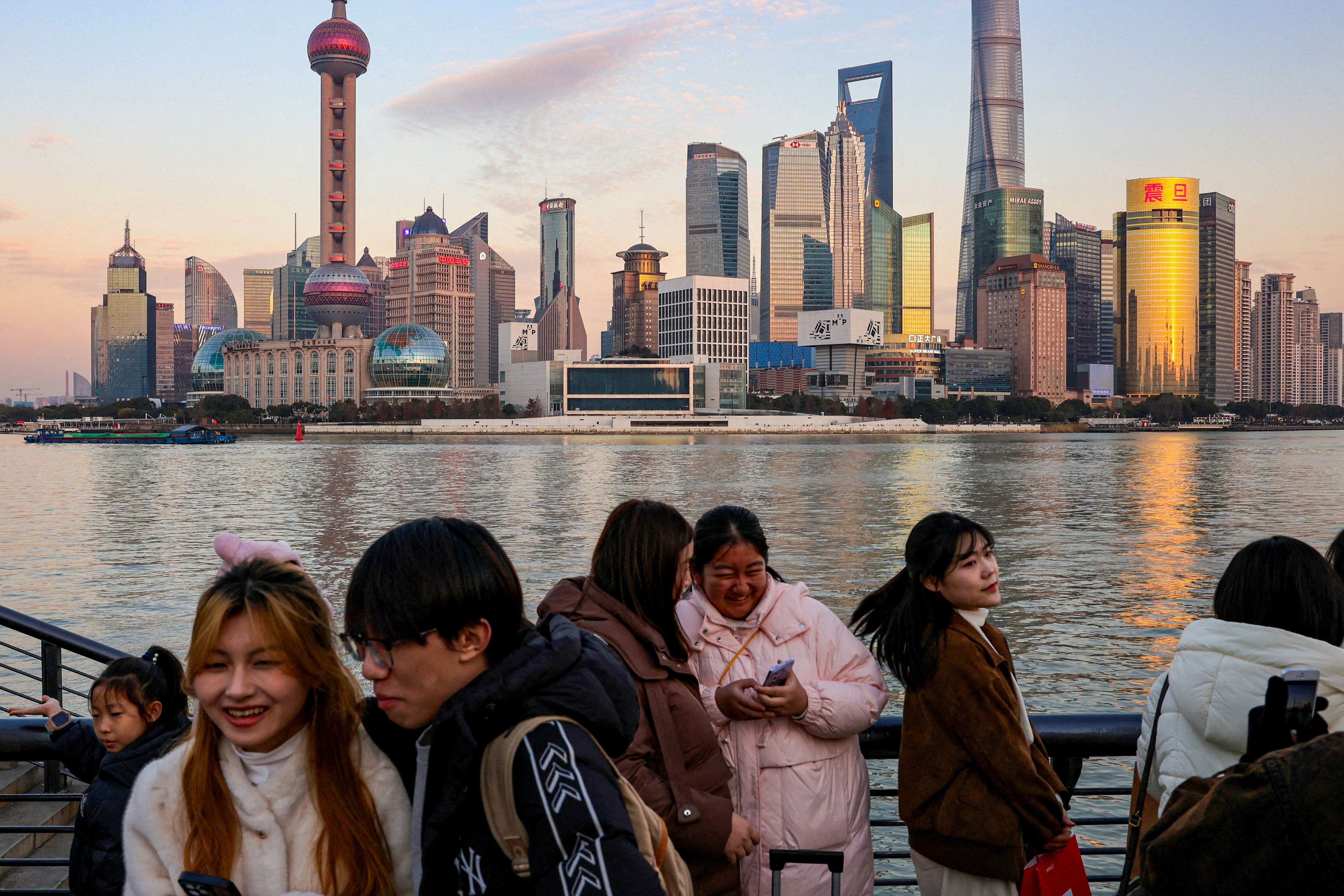 People hang out at The Bund as the financial district of Pudong is seen in the background in Shanghai. Photo: Reuters