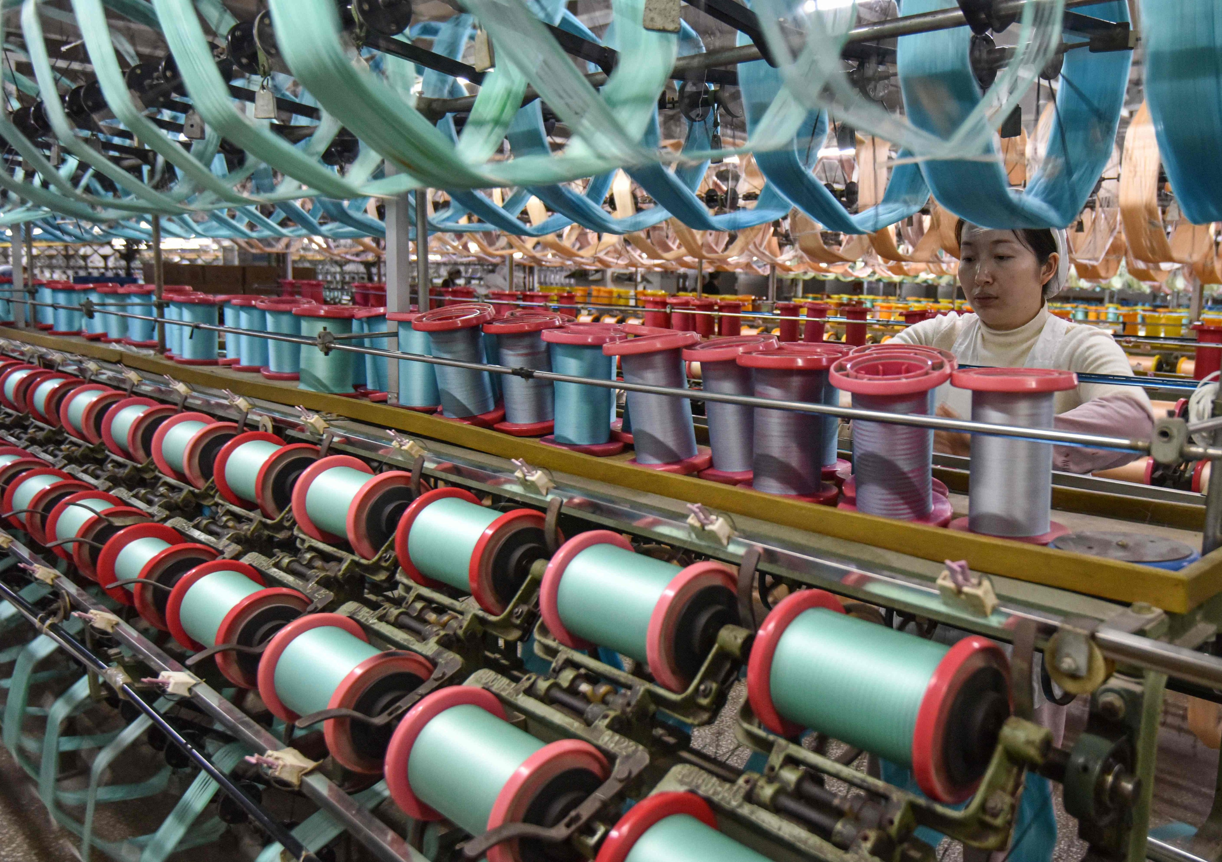 An employee works on a silk production line at a textile factory in Fuyang, in eastern China’s Anhui province on January 16, 2025. Photo: AFP