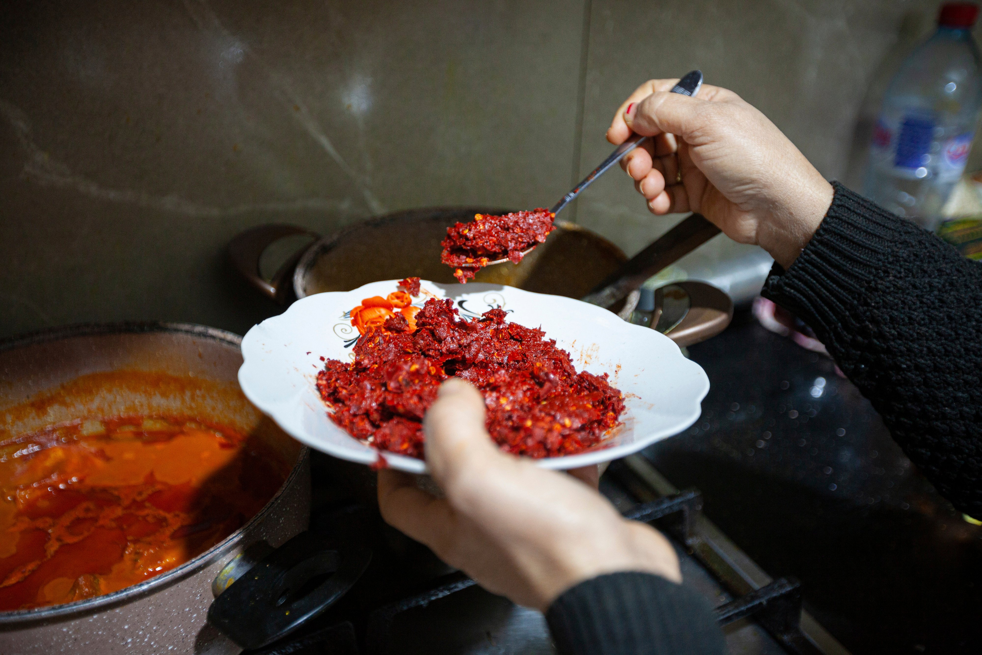 A Tunisian harissa maker at work in her home. Photo: AP