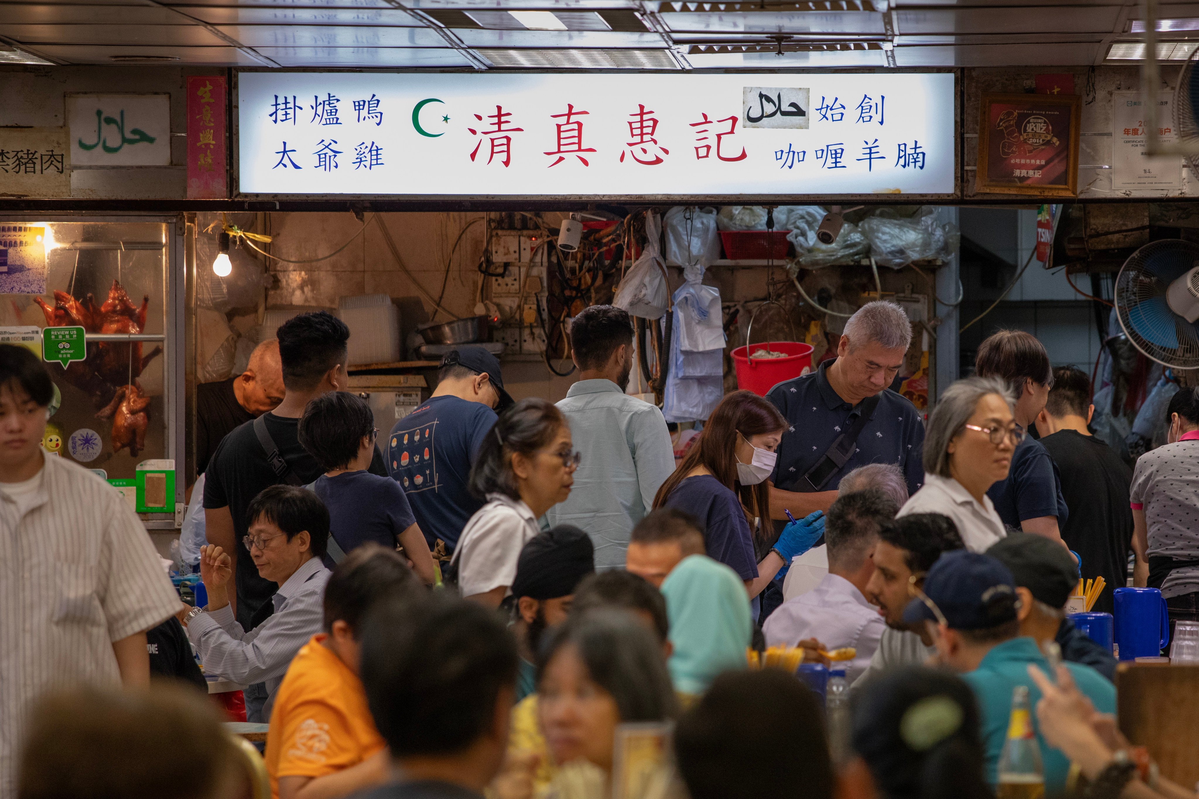 Customers sit and stand around a halal eatery in Bowrington Road Market, Wan Chai, on October 19. Photo: Antony Dickson