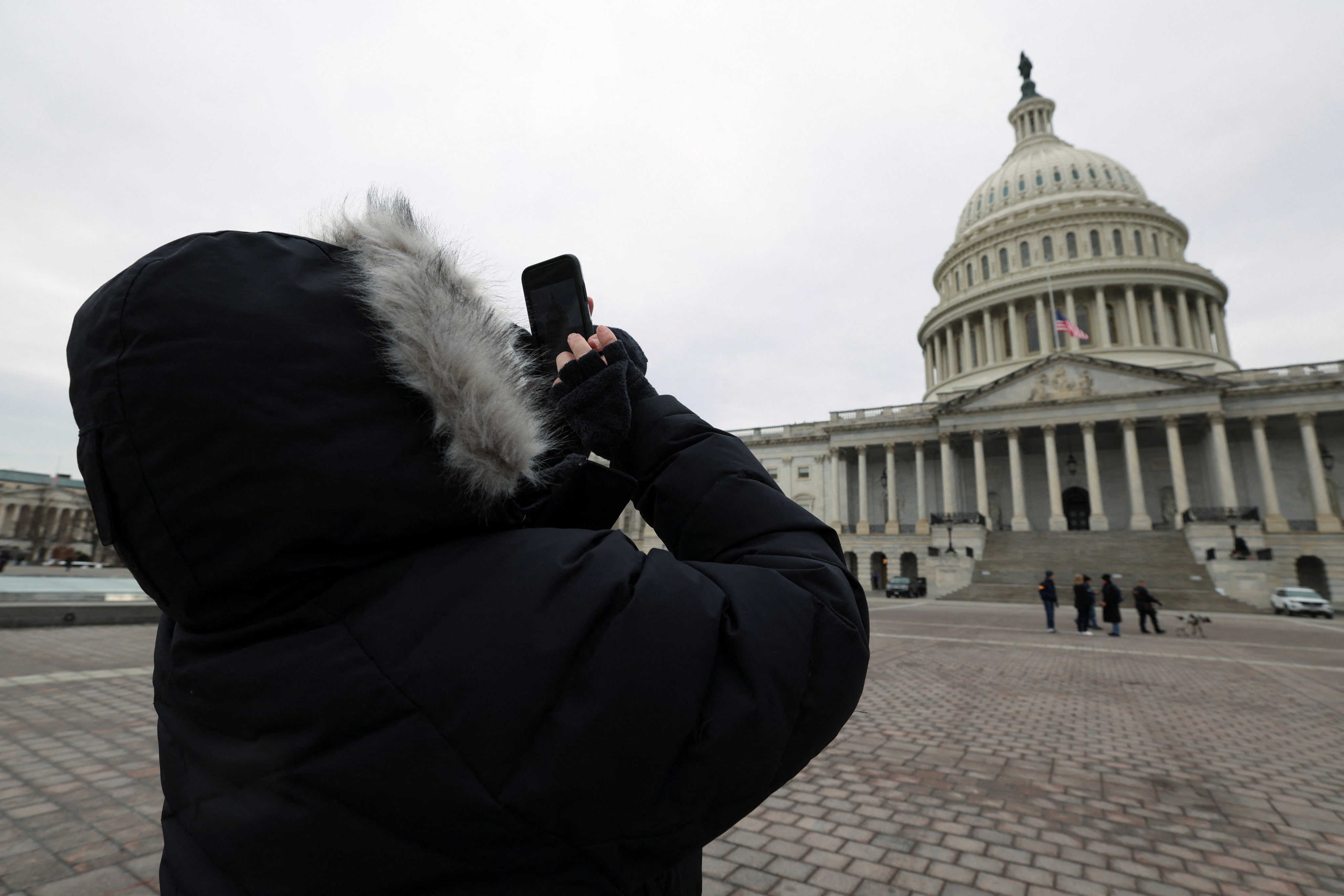 A women dressed in heavy winter clothing takes a picture of the US Capitol’s dome on Friday after it was announced that US president-elect Donald Trump’s inauguration is being moved indoors due to dangerously cold temperatures expected on Monday. Photo: Reuters