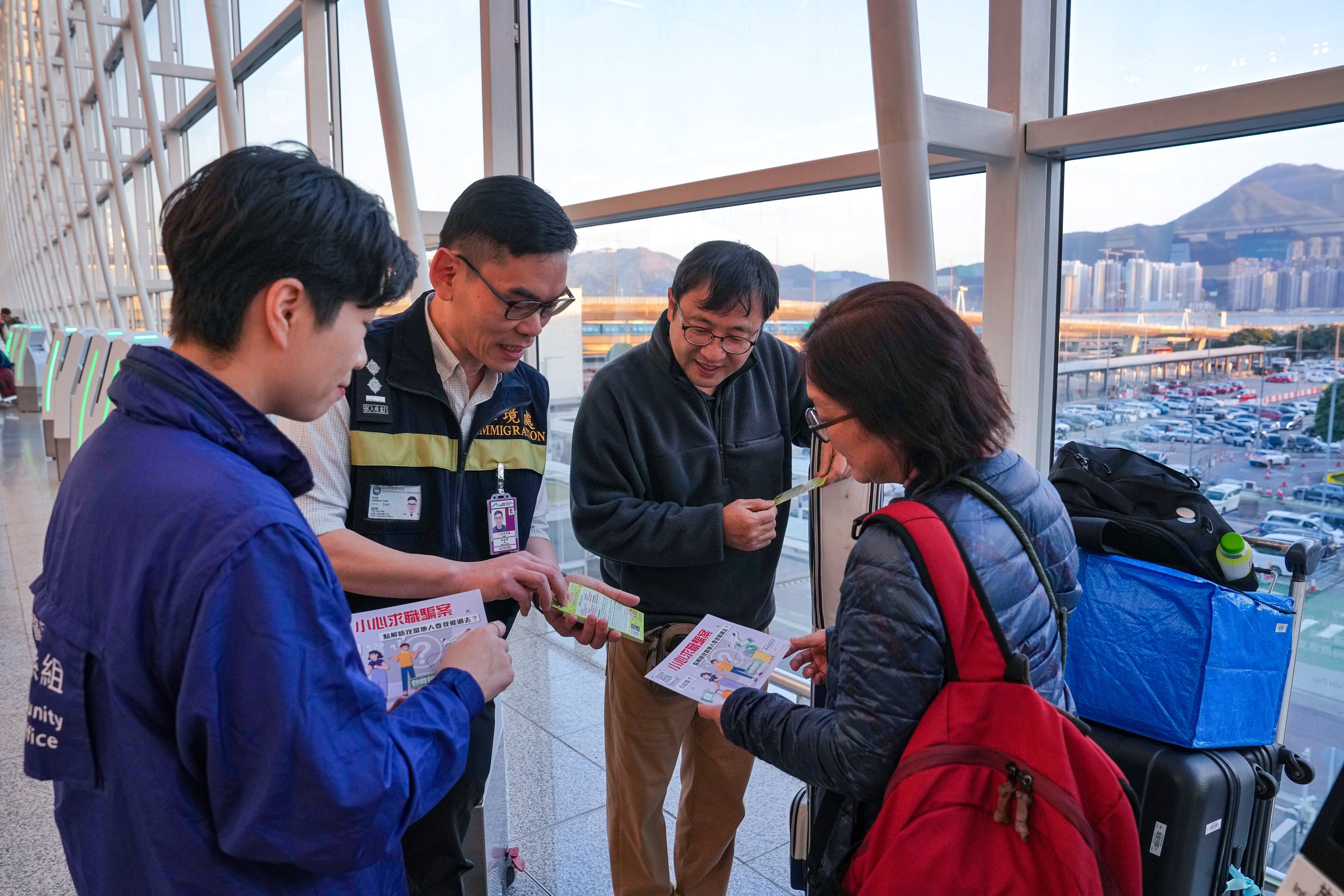 Police and Immigration Department officers distribute leaflets to travellers warning against job scams and human trafficking. Photo: Elson Li