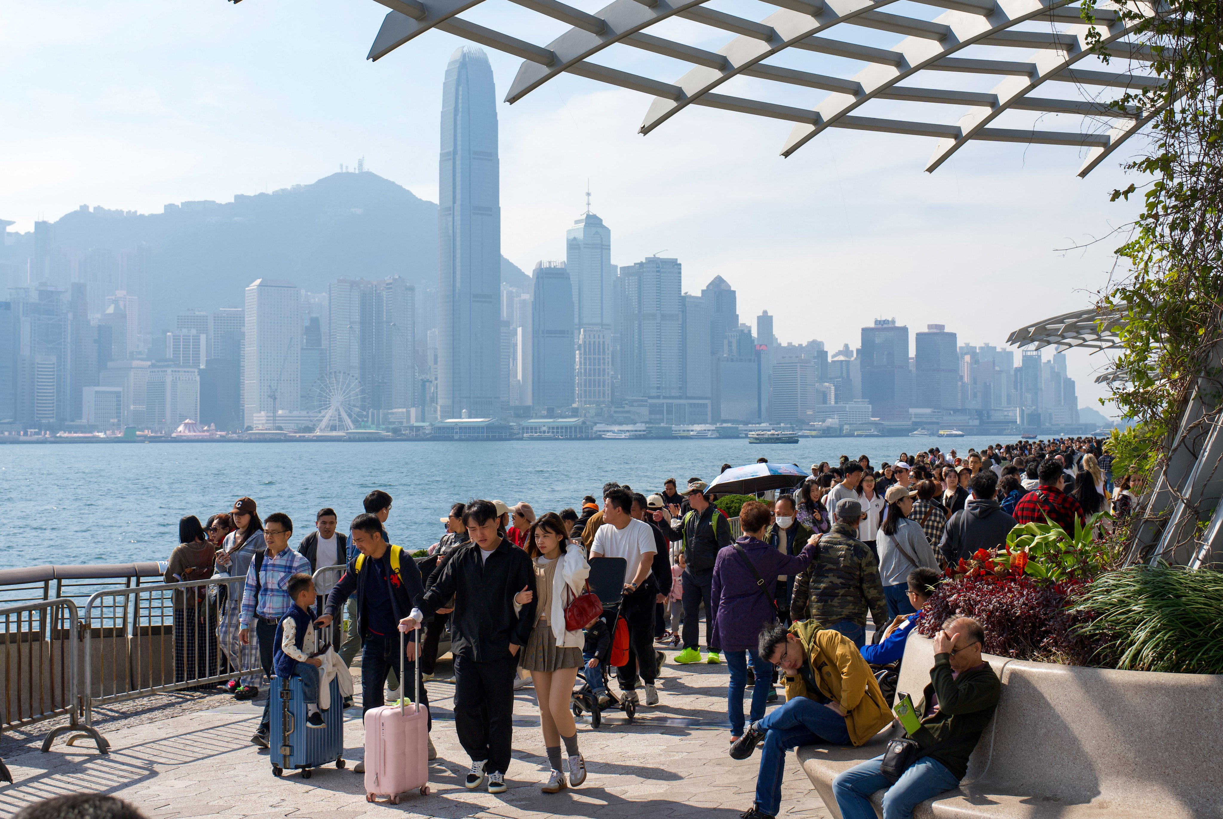 Mainland tourists enjoy a view of Victoria Harbour from the waterfront in Tsim Sha Tsui. Photo: Sam Tsang