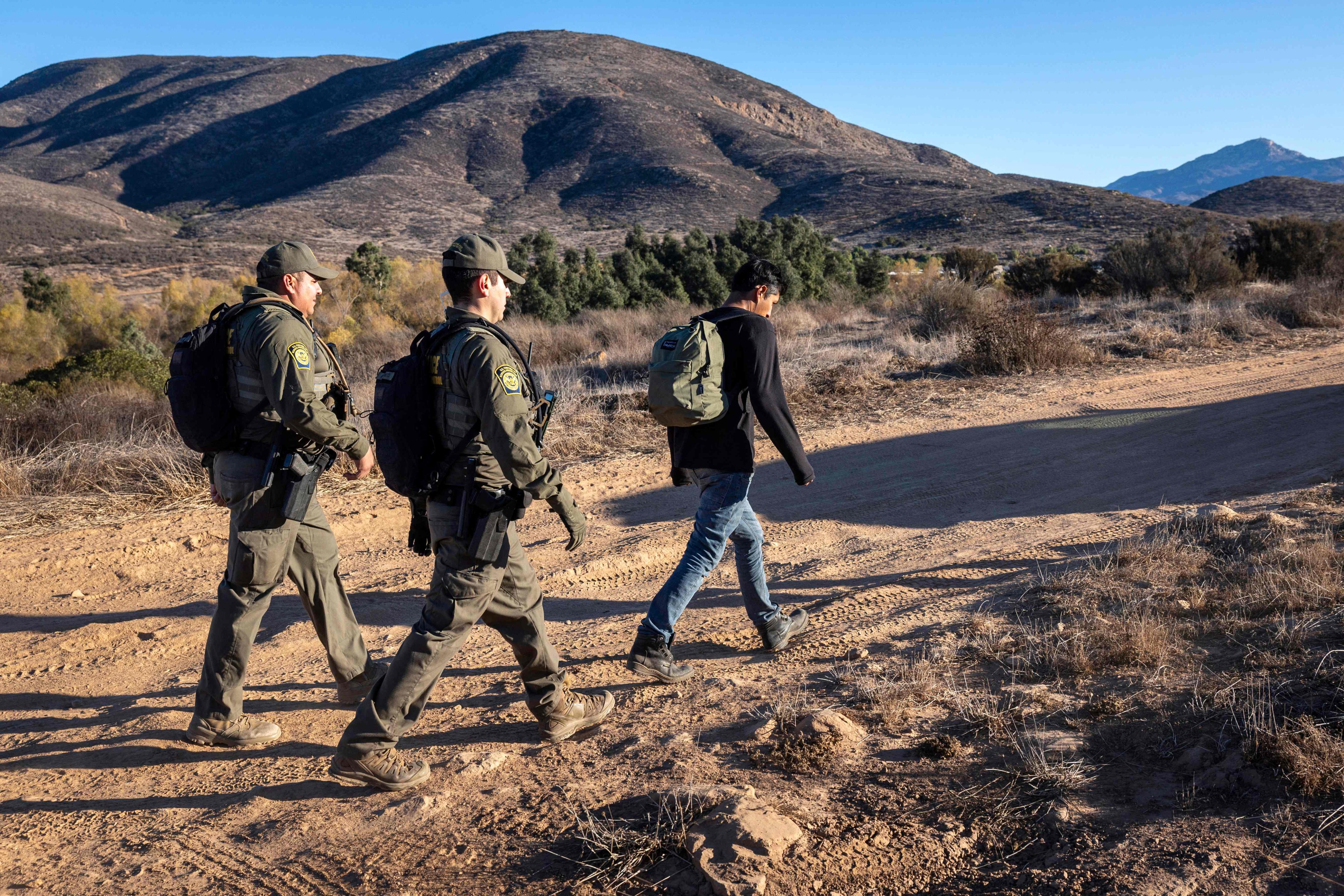 US Border Patrol agents detain a migrant who crossed the frontier from Mexico near Jamul, California, on January 15. Photo: Getty Images via AFP