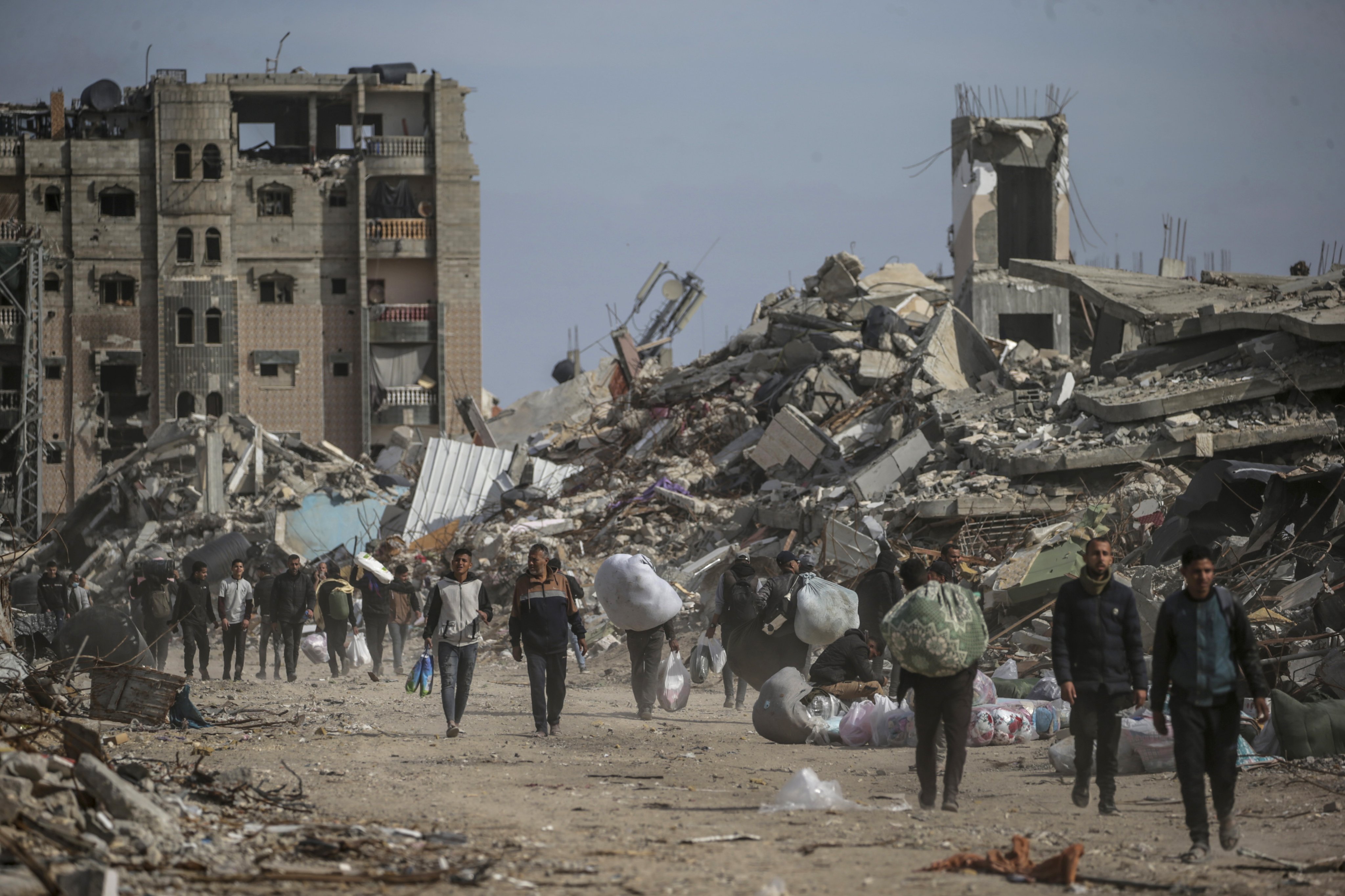 Displaced Palestinians walk near the rubble of destroyed buildings in Rafah, southern Gaza Strip on January 19, amid a ceasefire between Israel and Hamas. Photo: EPA-EFE