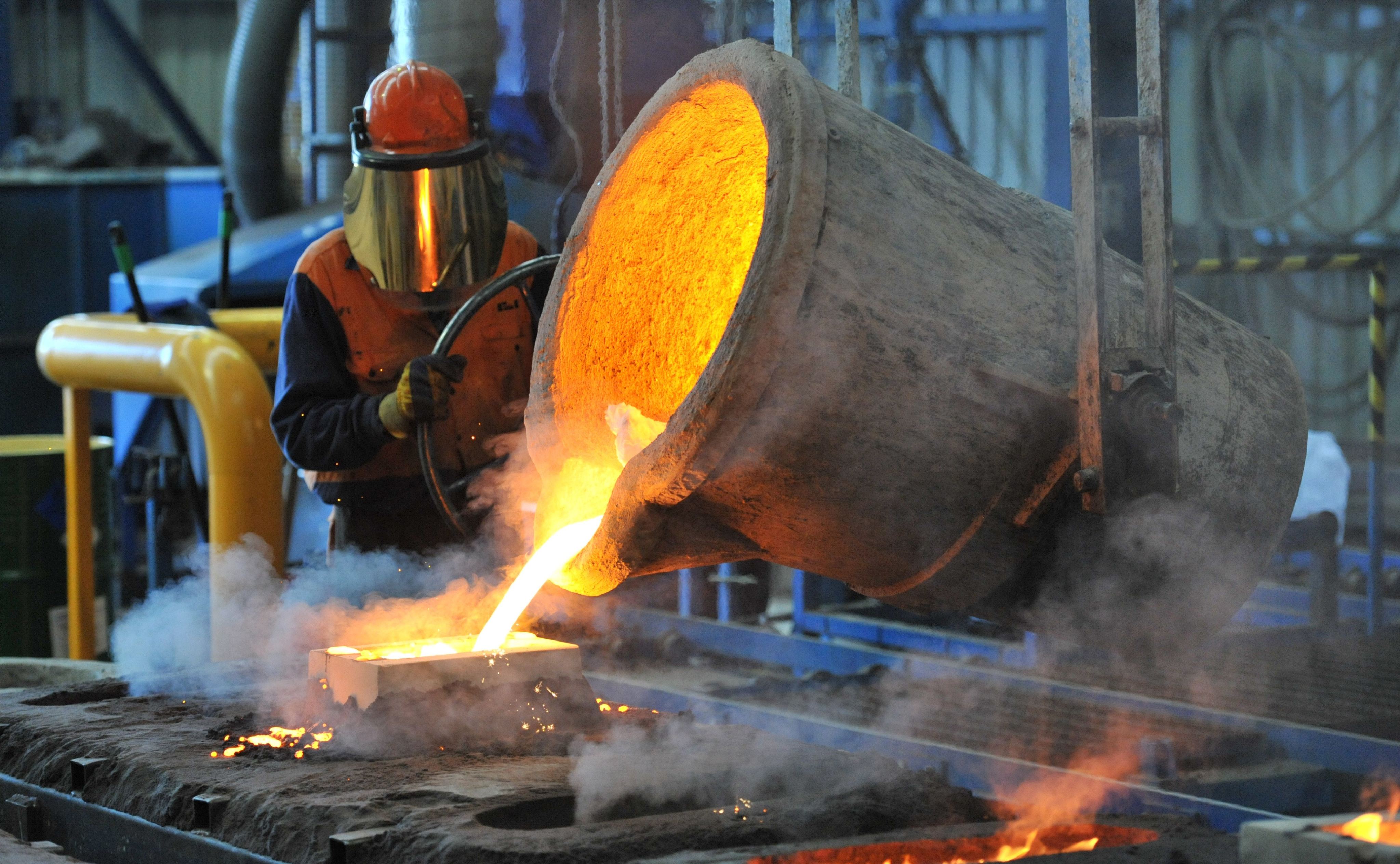 Molten iron is poured by a factory worker in Geelong, Australia. Photo:  EPA-EFE/FIle