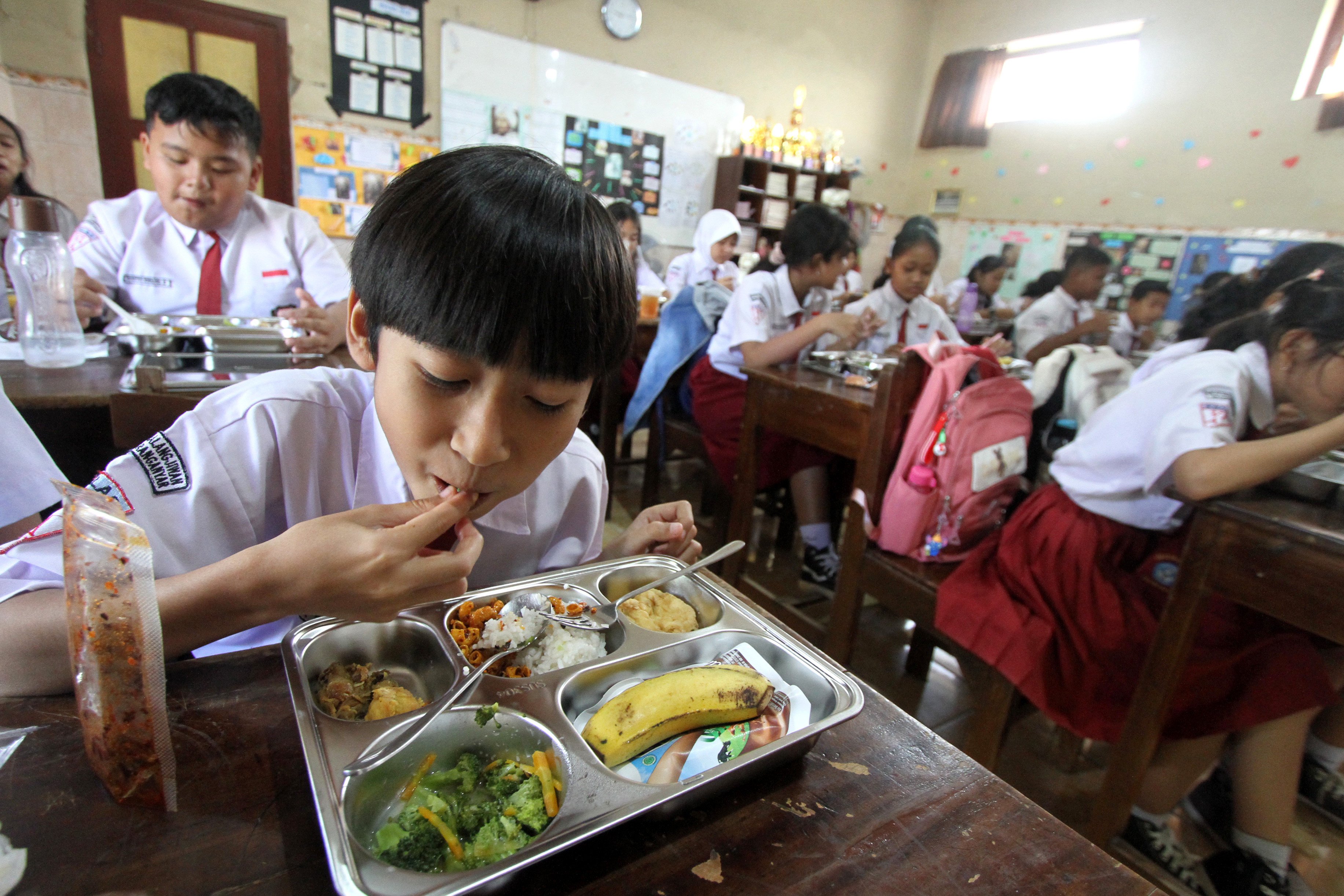 Pupils enjoy their breakfast in Surakarta, Central Java, Indonesia, on January 6 as 
 part of a free-meal scheme. Photo: Xinhua