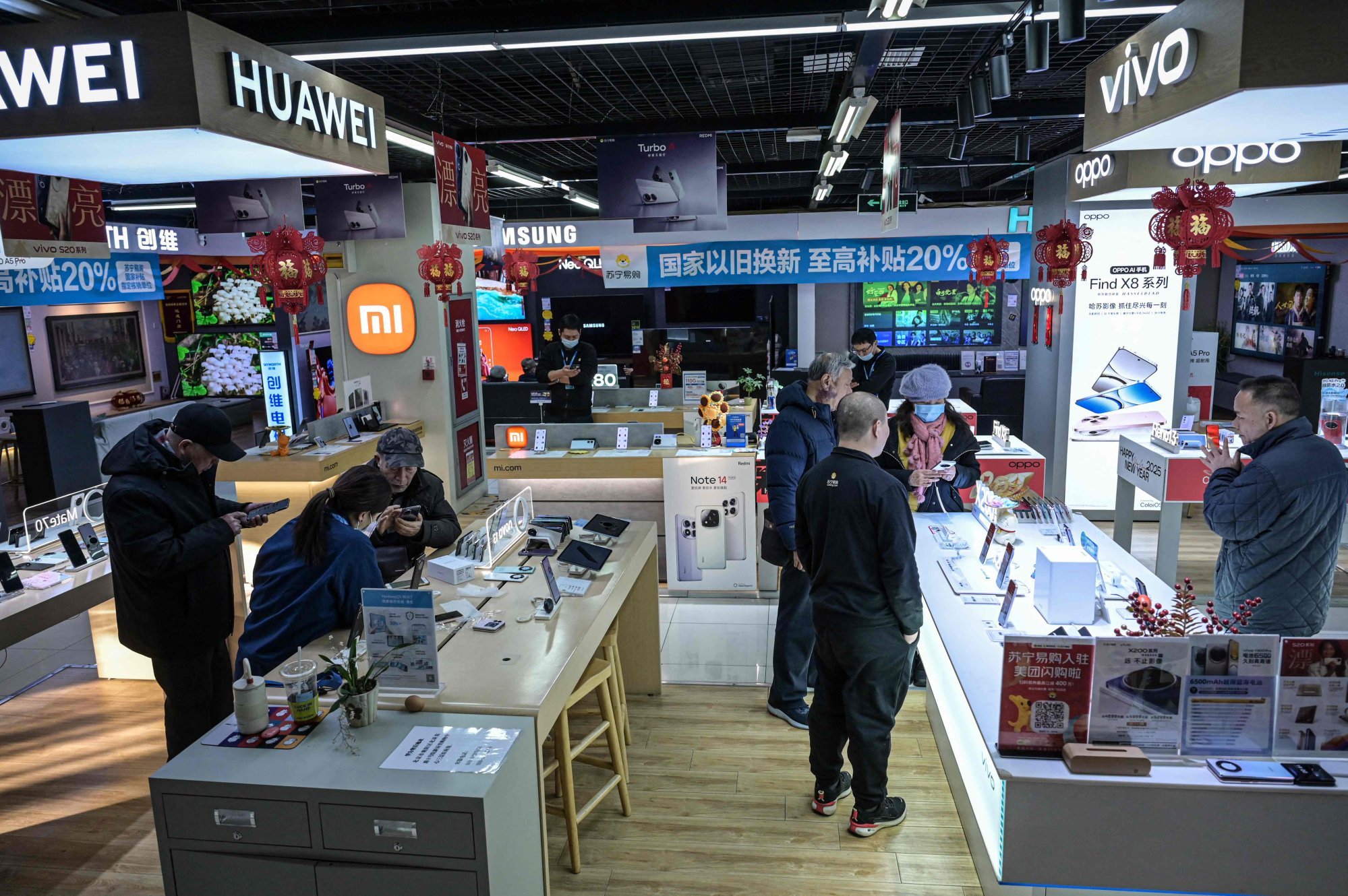 Customers shop for smartphones at a Suning electronics store in Beijing, Jan. 15. AFP-Yonhap