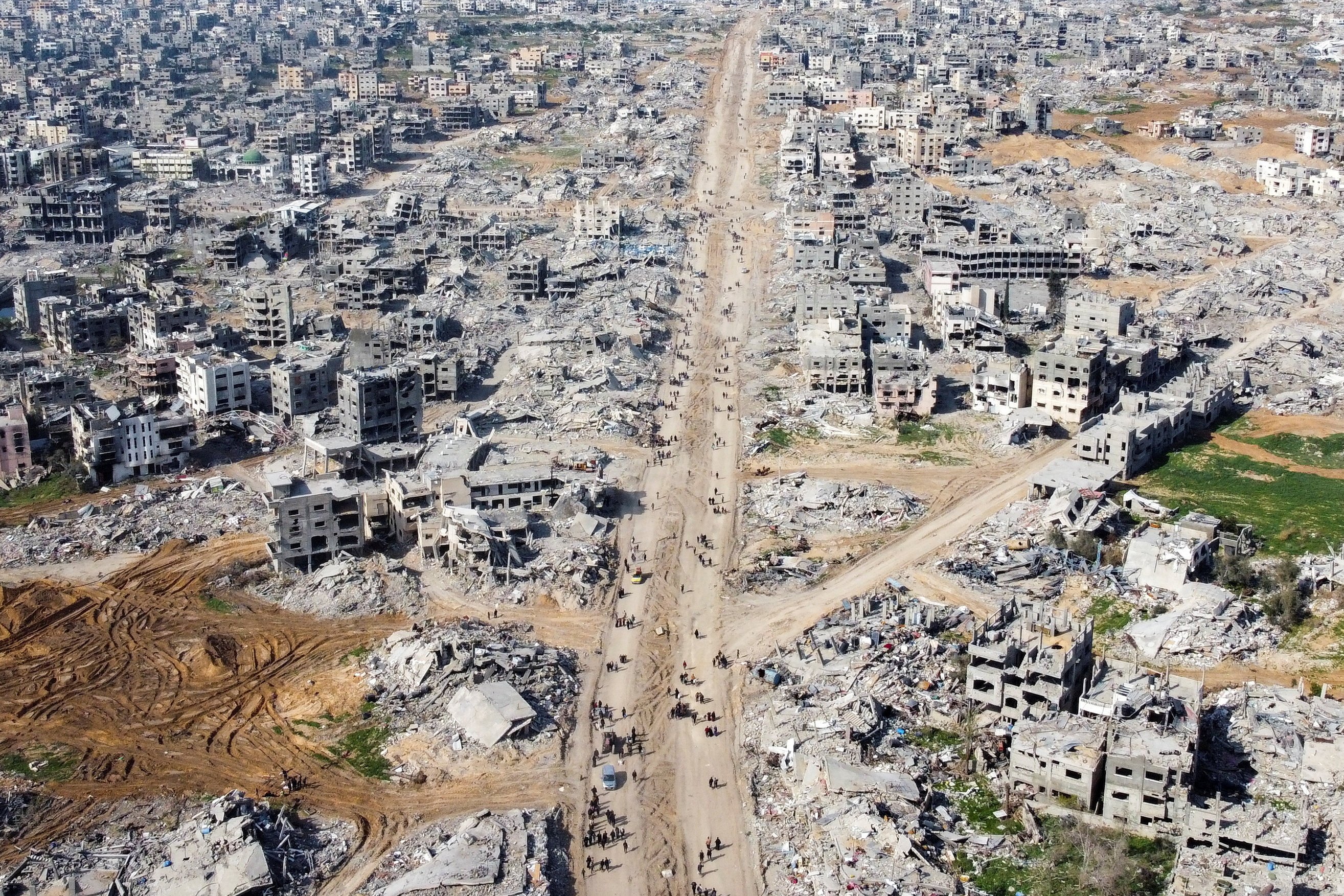 Palestinians walk past the rubble of houses and buildings in Jabilia in the northern Gaza Strip. Photo: Reuters