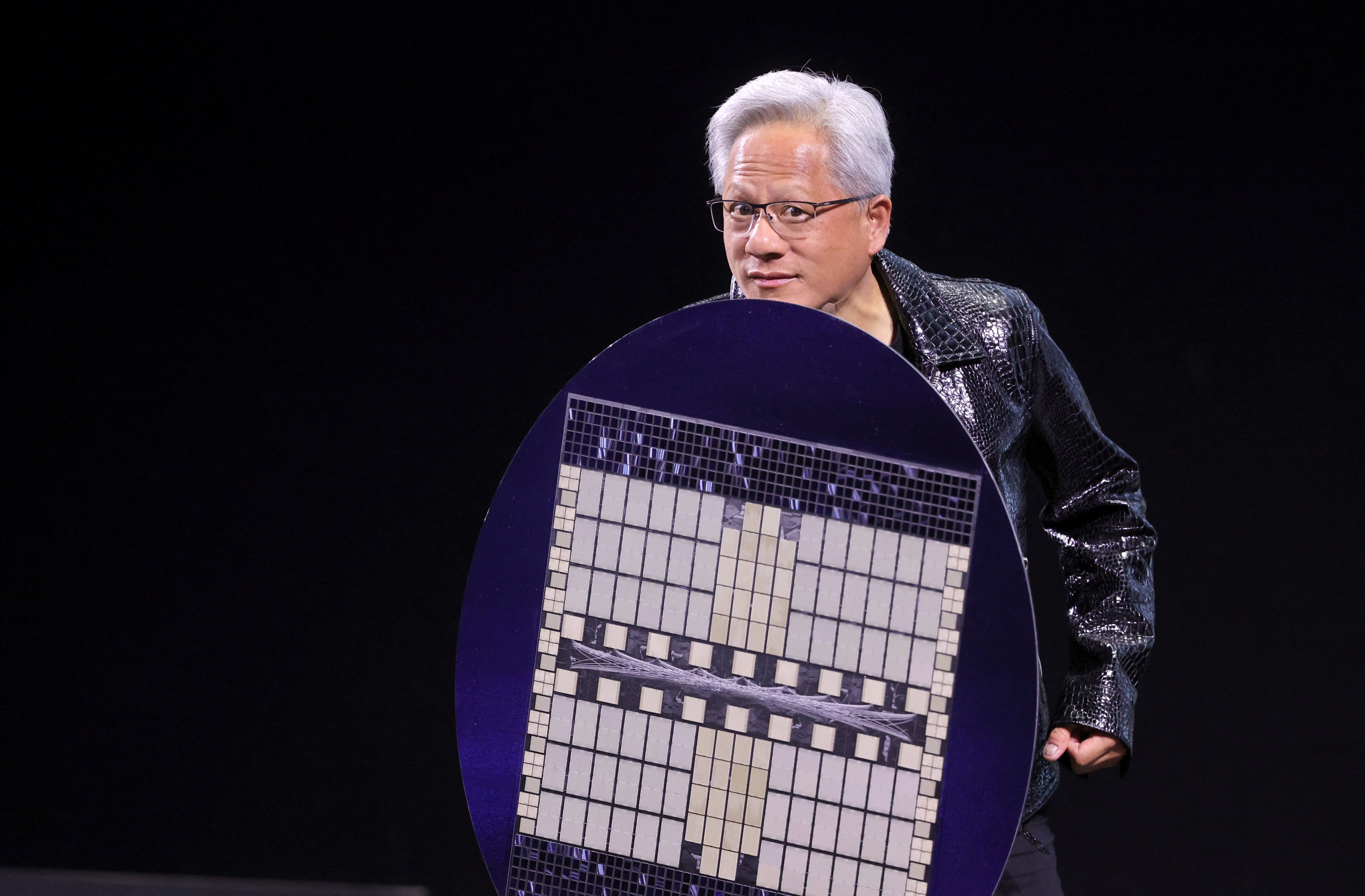 Nvidia CEO Jensen Huang holds a computer chip mock-up during a speech at CES 2025 in Las Vegas. Photo: Reuters