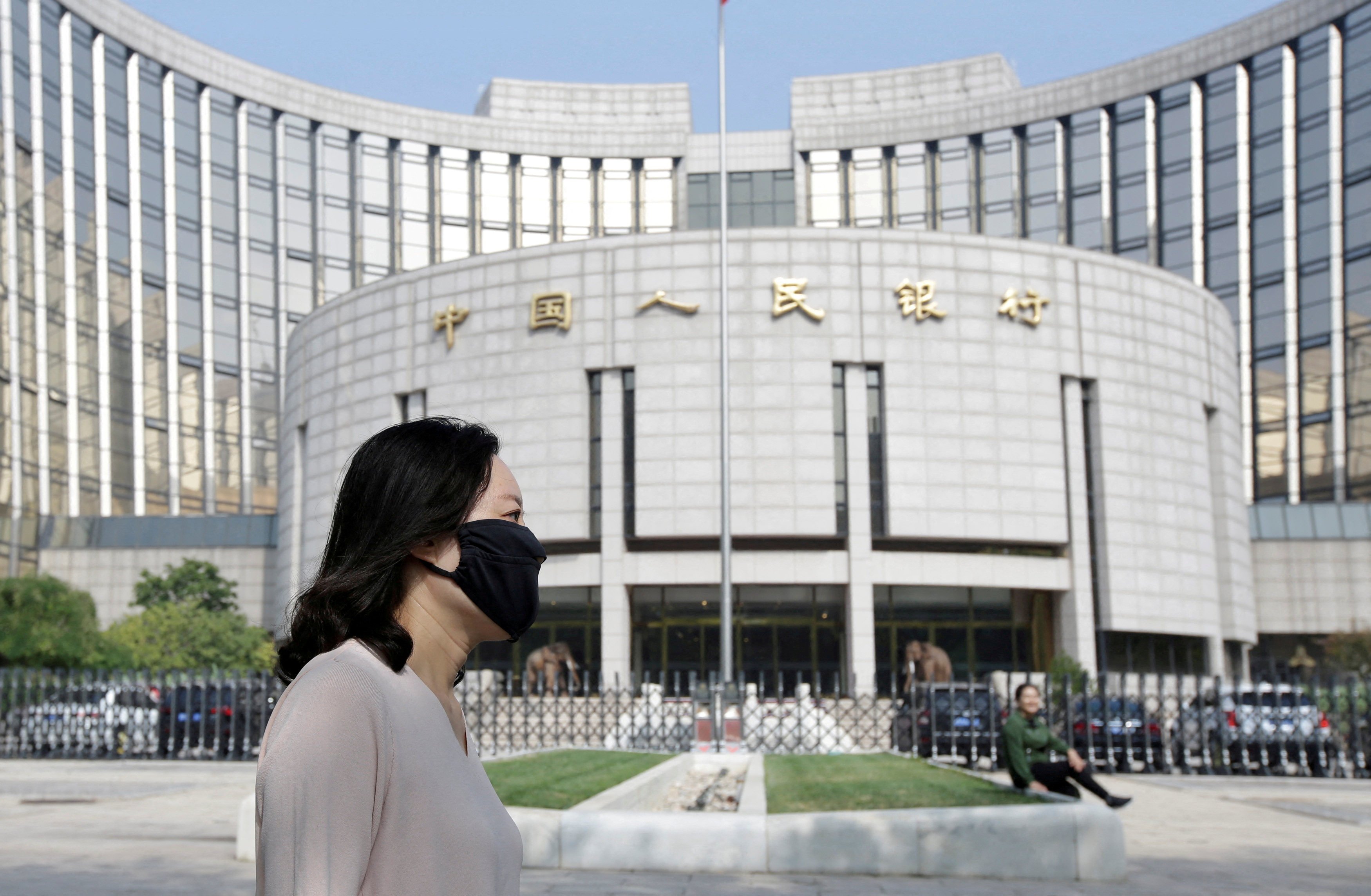 A woman passed the headquarters of the People’s Bank of China in Beijing. Photo: Reuters 