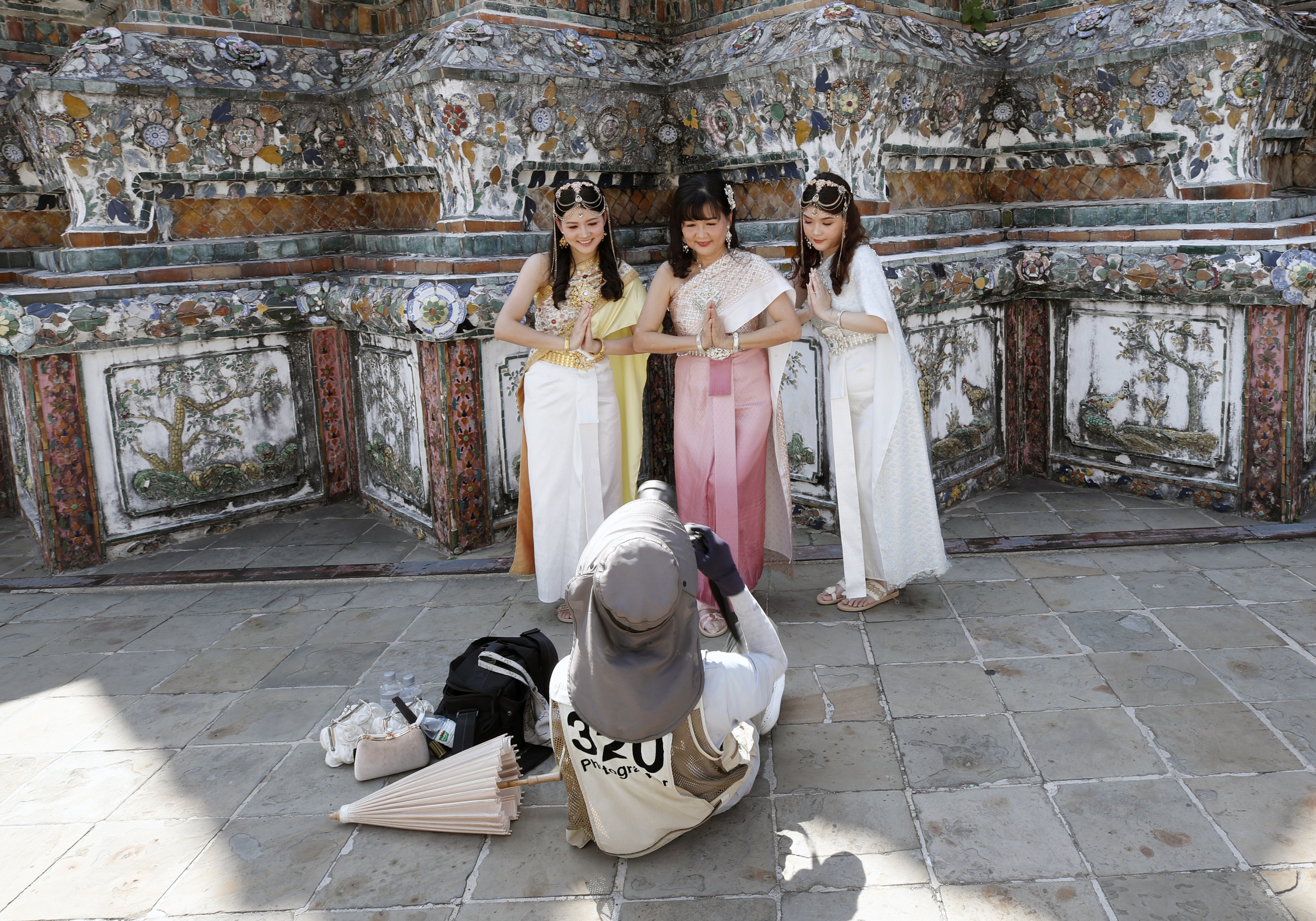 Chinese tourists do a Thai traditional greeting while posing for photographs at the Temple of Dawn, or Wat Arun, in Bangkok, Thailand, earlier in January. Photo: EPA-EFE