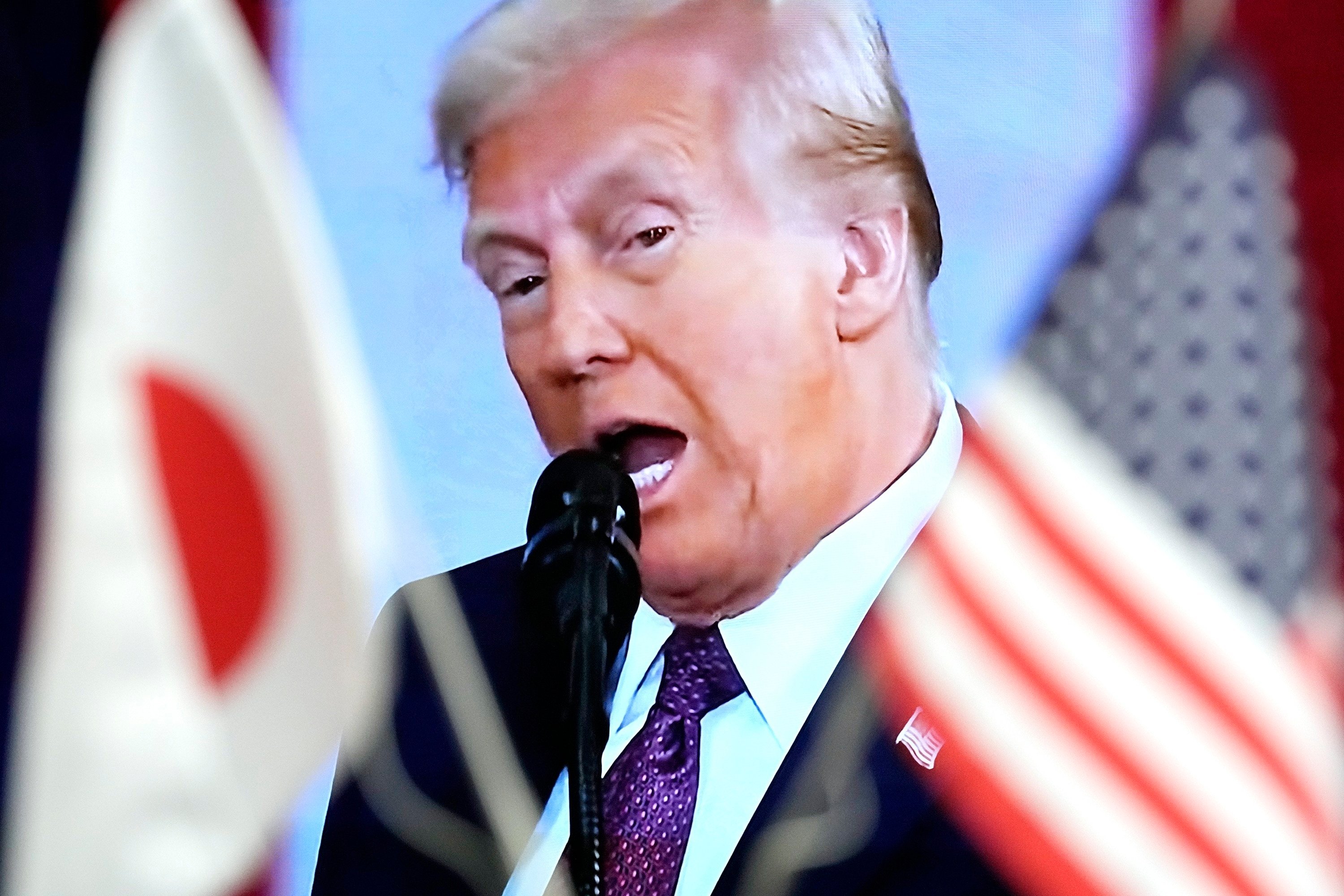 Japanese and US flags are seen in front of a monitor showing US President Donald Trump delivering a speech at his inauguration ceremony on Monday. Photo: AP