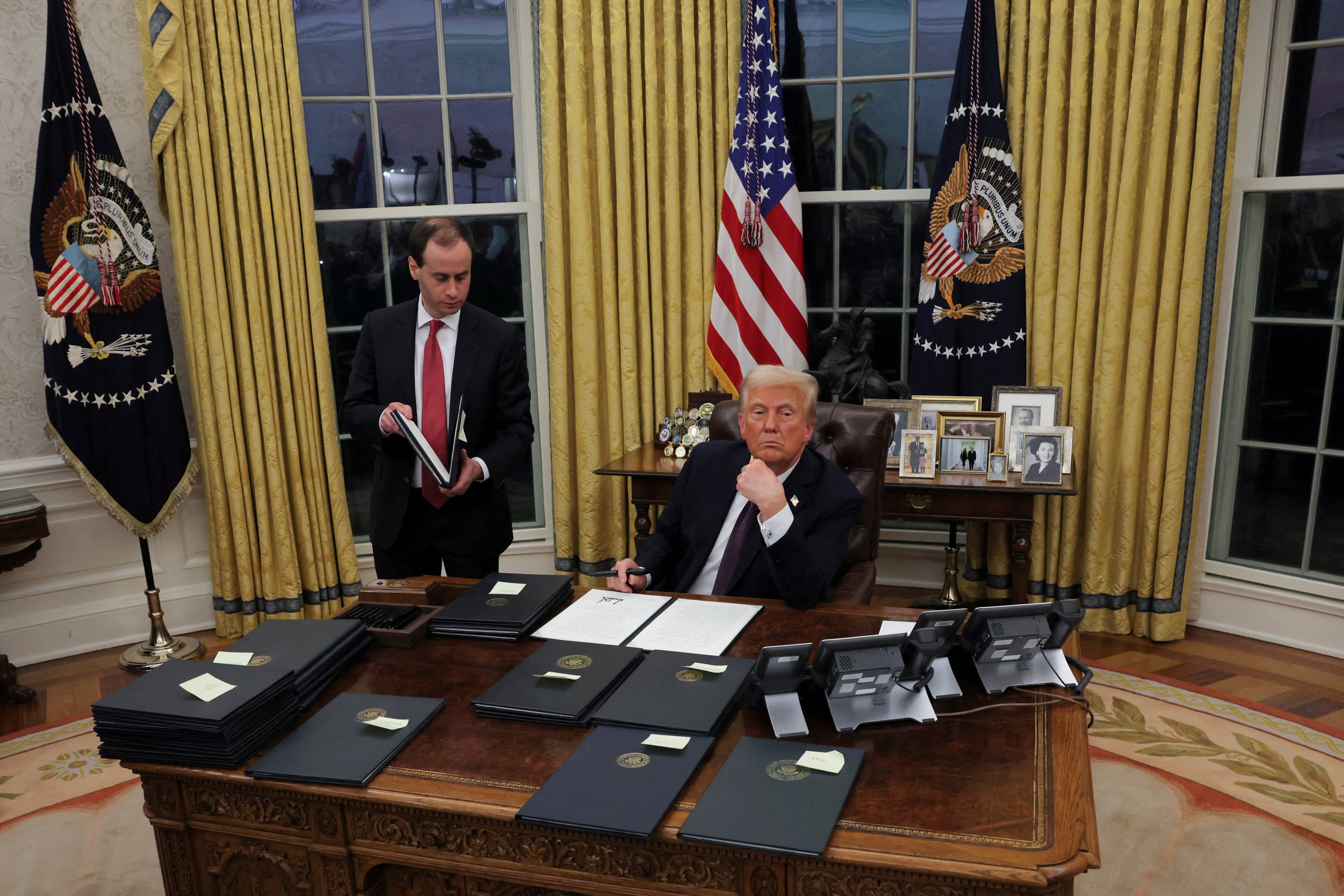 US President Donald Trump signs documents as he issues executive orders, in the Oval Office on Monday, his first day back in the White House. Photo: Reuters  