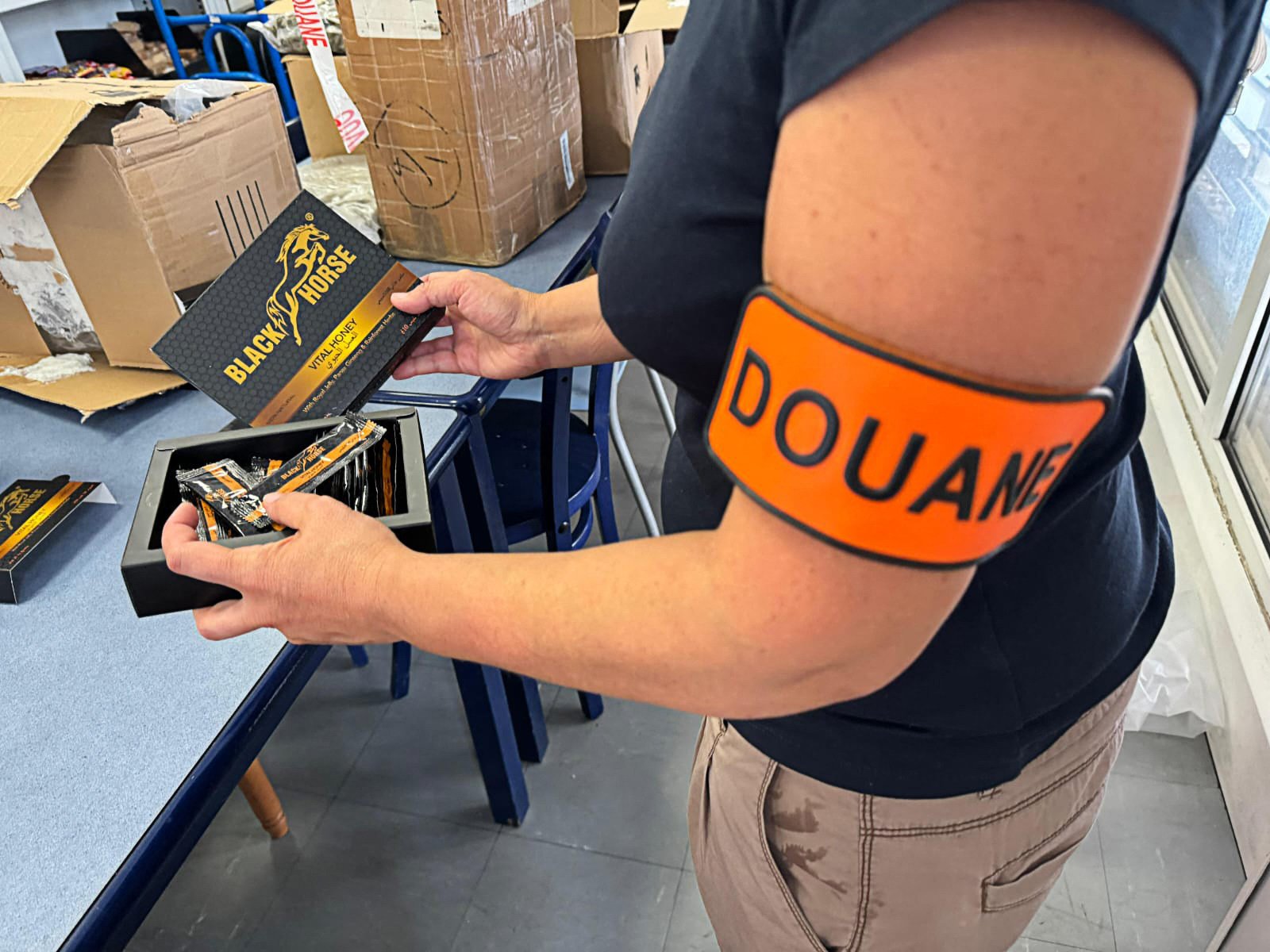 A French customs officer holds packs of illegally imported “Black Horse” honey touted as an all-natural sexual enhancement. Photo: Douanes Francaises/AFP