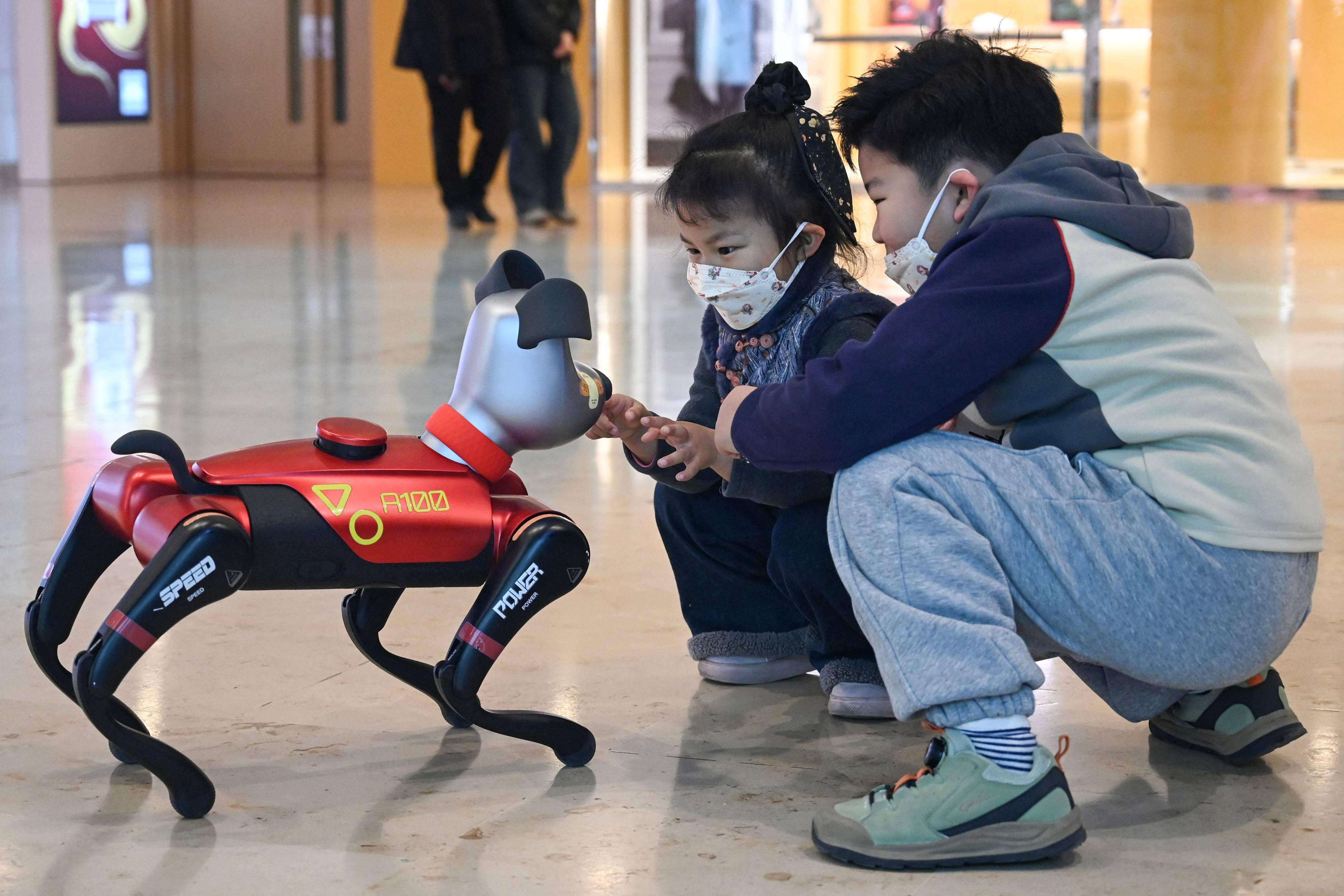 Children interact with an AI dog in Nanjing. Photo: AFP 