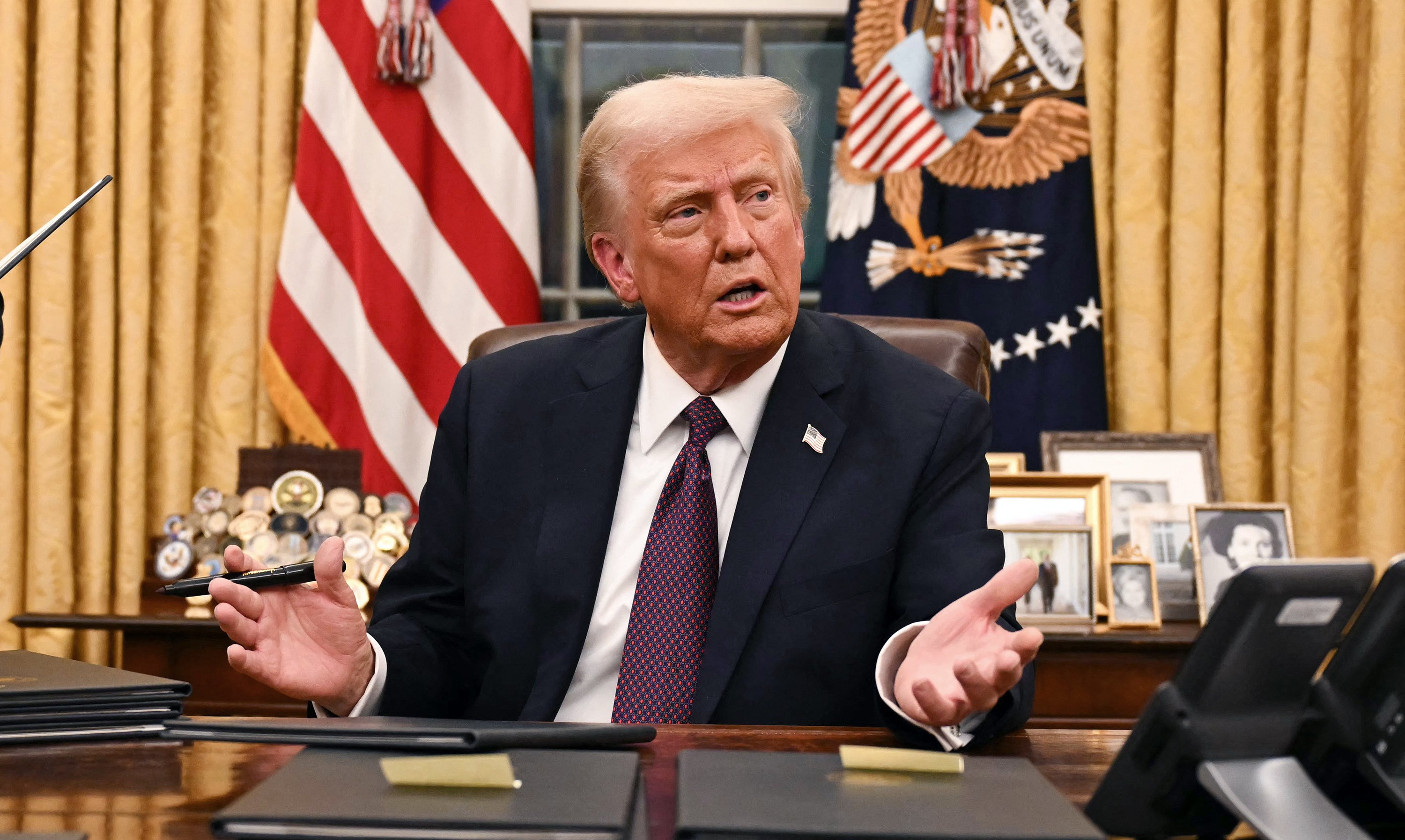 US President Donald Trump speaks to journalists in the Oval Office of the White House in Washington on Monday. Trump’s threats to punish countries that move away from the US dollar has sparked criticism. Photo: AFP