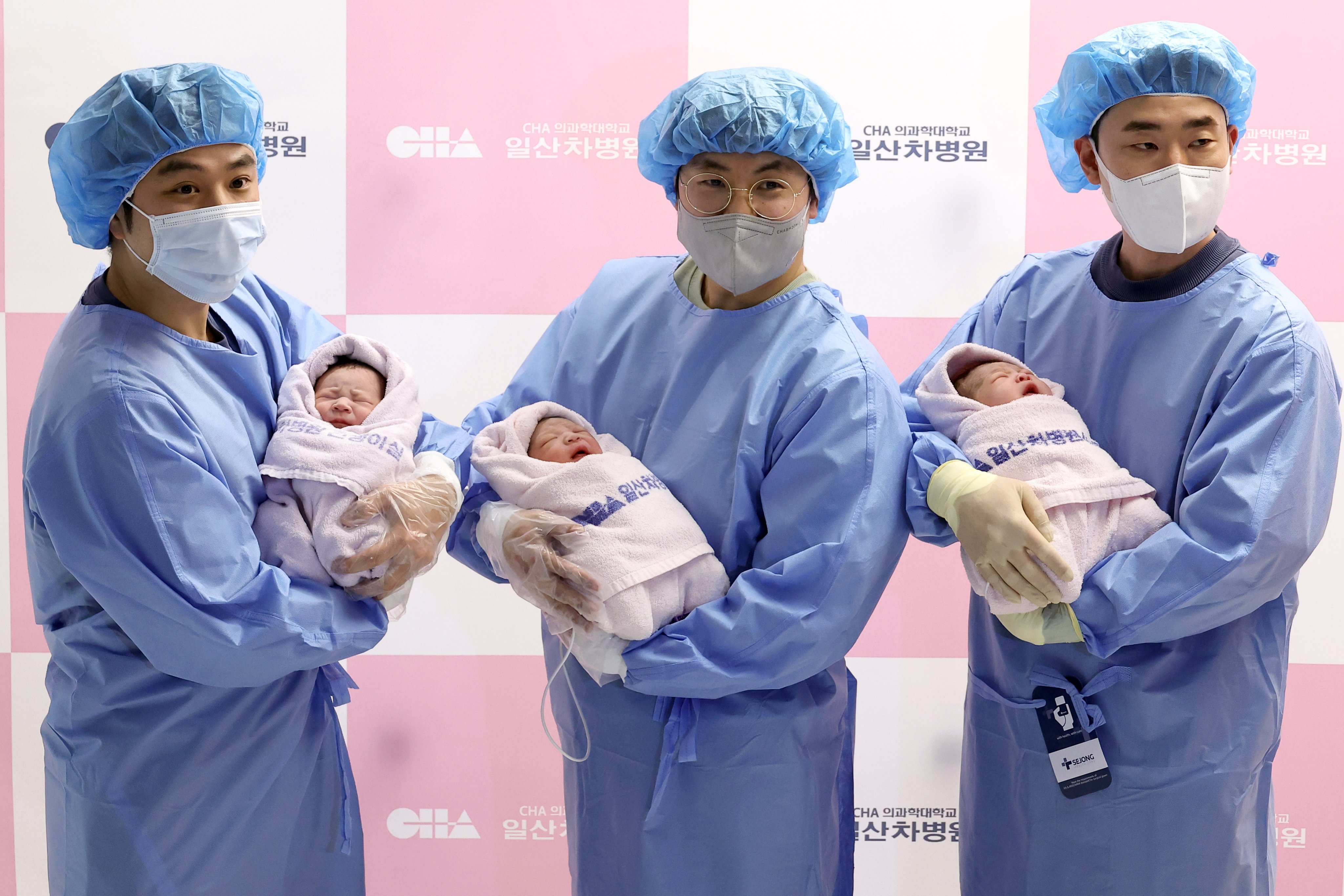 Fathers hold their newborn babies at a hospital in Goyang, near Seoul, South Korea, on January 1. Photo: Yonhap/EPA-EFE