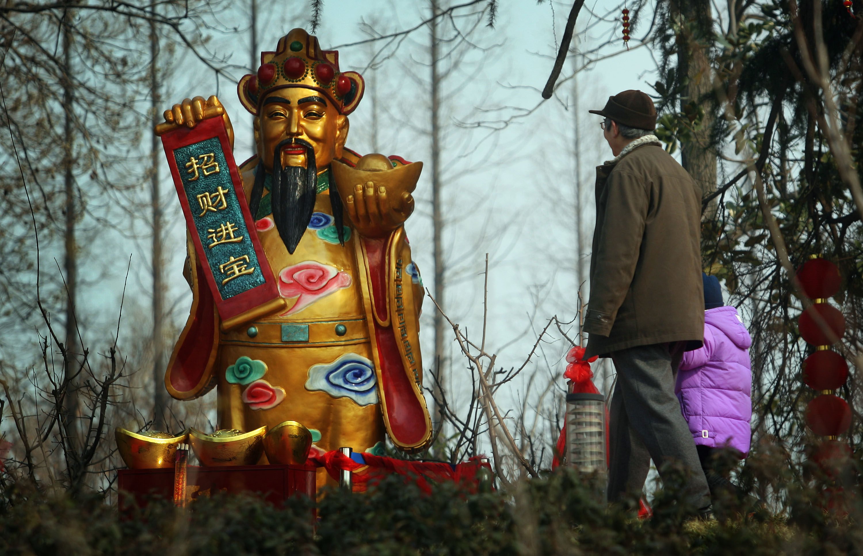 A statue of the god of wealth stands in a forest in Nanjing, in China’s Jiangsu province. The god is one of the many guardian deities that Chinese people traditionally pray to during Lunar New Year for fortune, health, love and prosperity. Photo: Getty Images