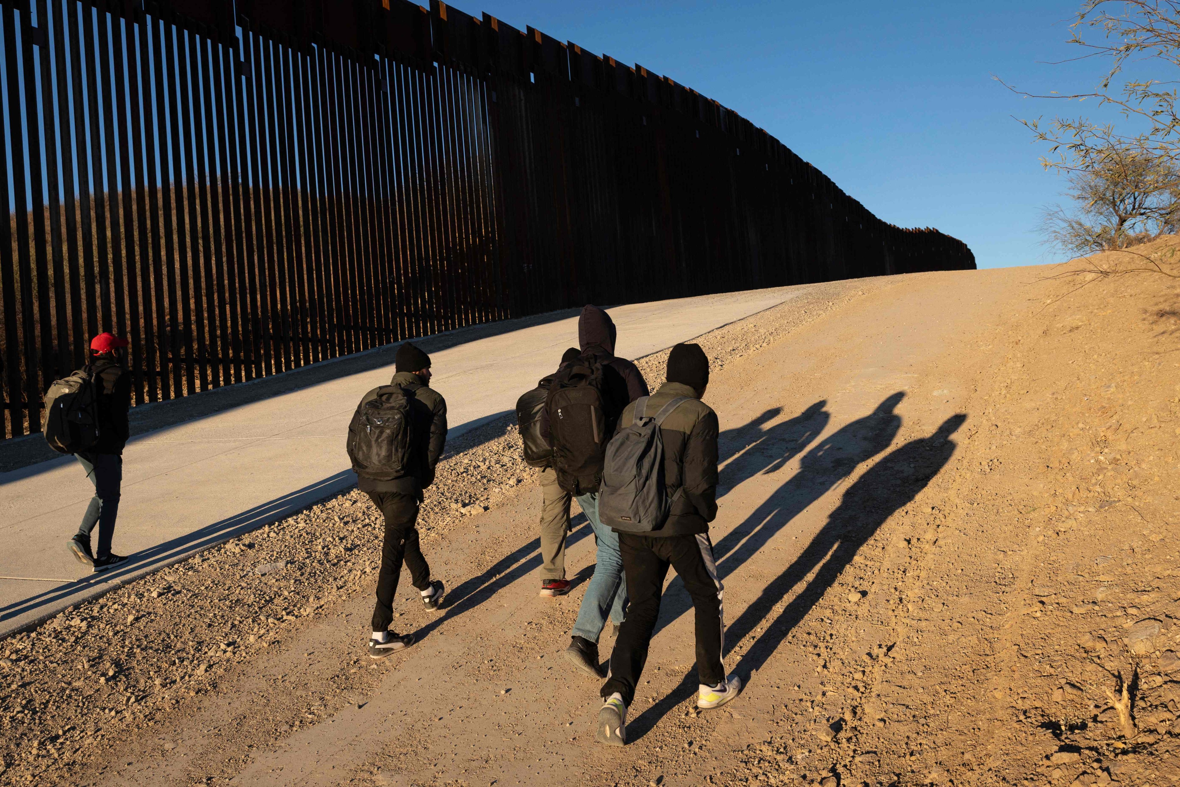 Immigrants from India walk next to the Trump-built US-Mexico border fence after crossing into Arizona on Sunday. Photo: AFP