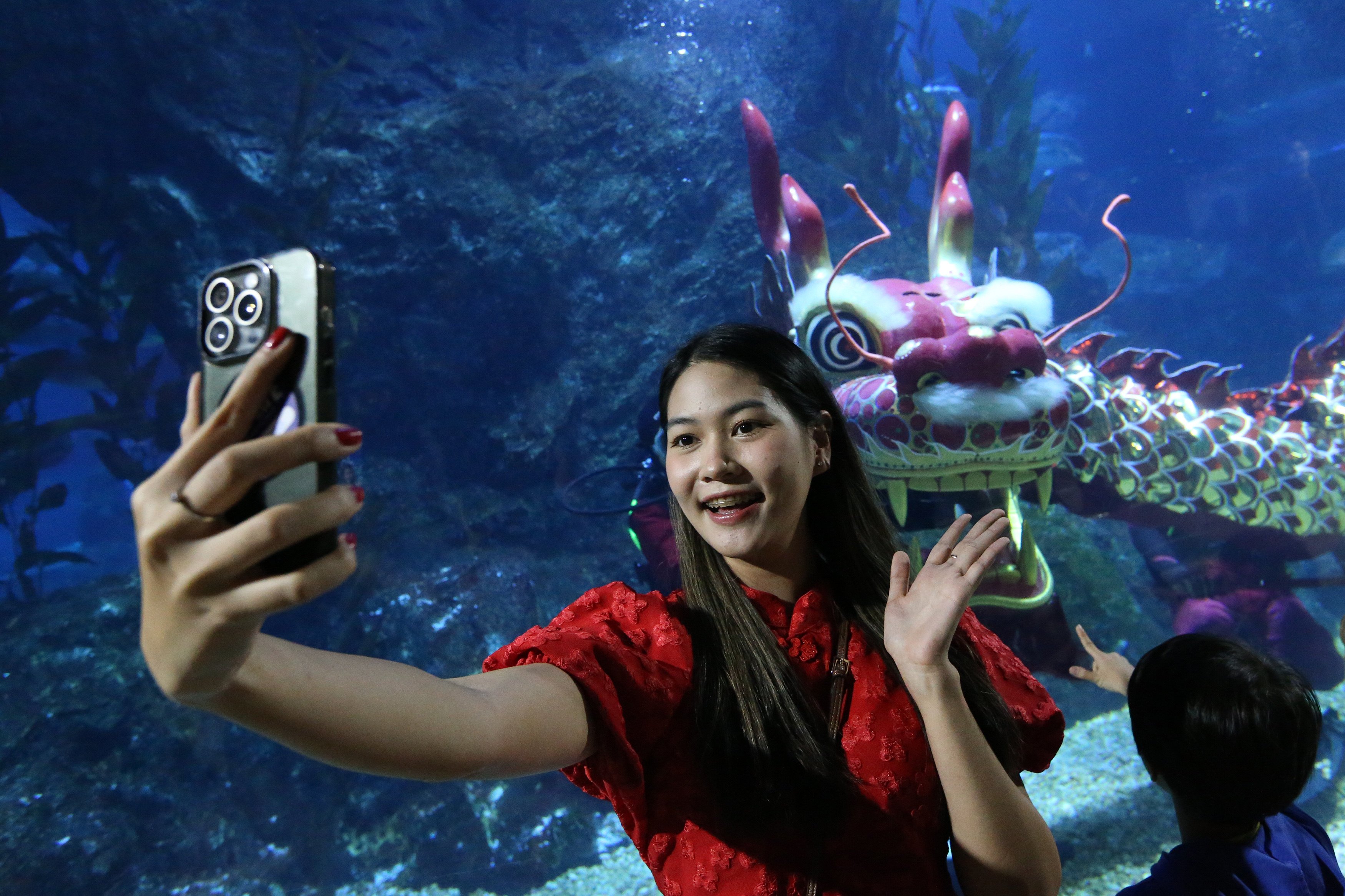 A tourist takes a selfie during an underwater dragon dance show in Bangkok, Thailand, last Thursday. Photo: Xinhua