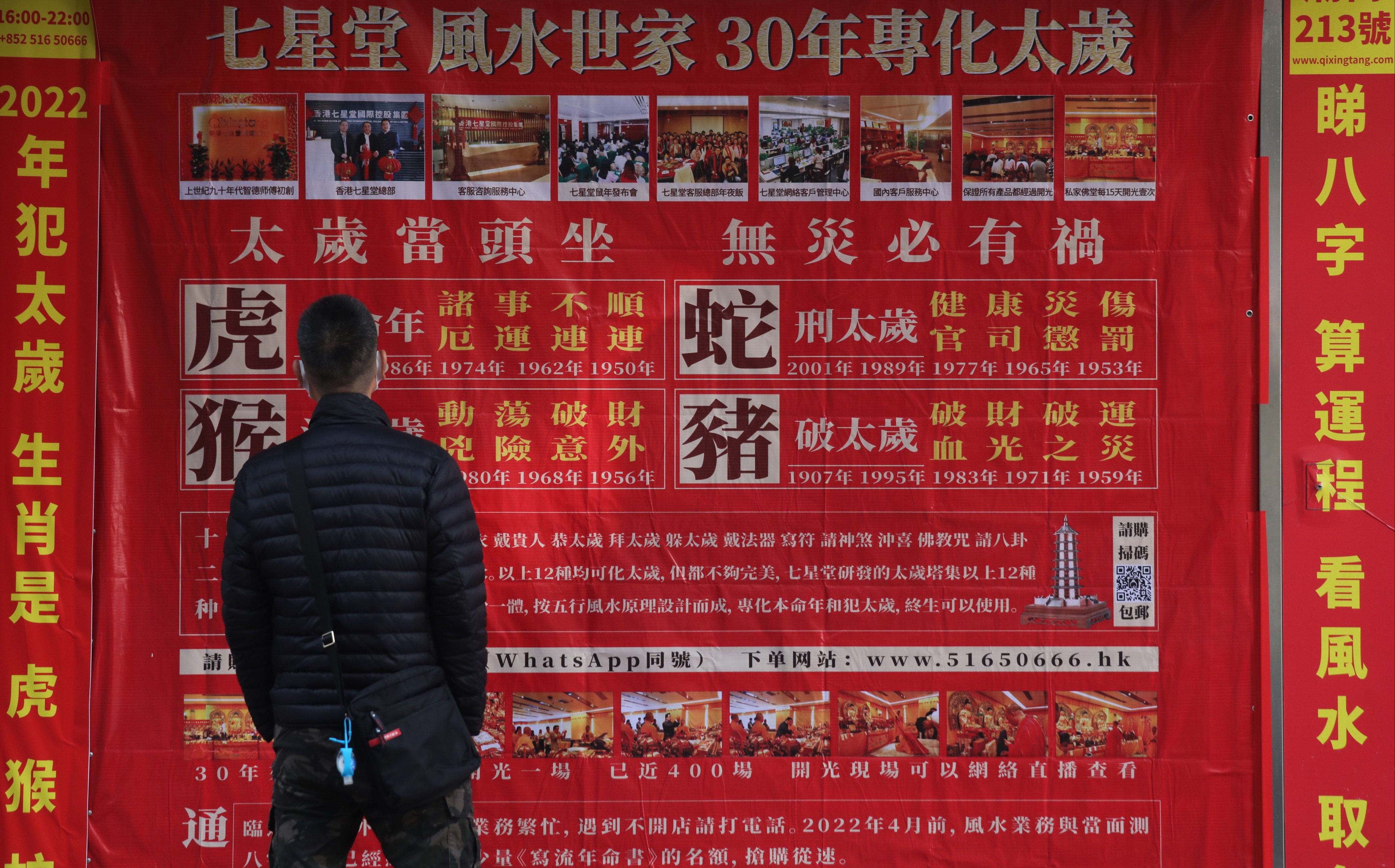 A man stops to read an advertisement in Yau Ma Tei in 2021 for a feng shui master’s services for Chinese zodiac signs facing a challenging year. Photo: Xiaomei Chen