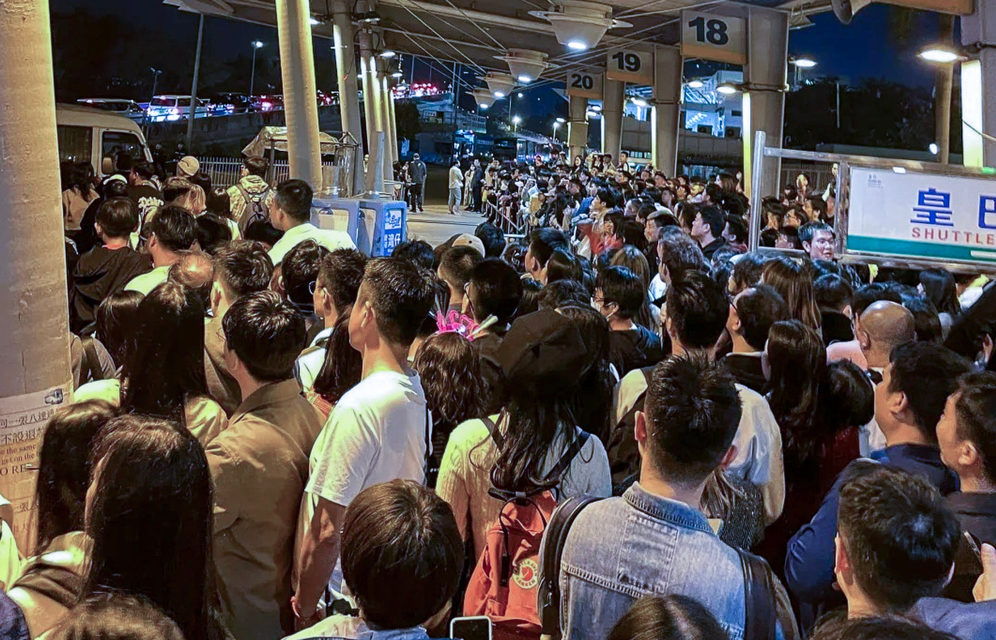 Mainland Chinese tourists wait for shuttle buses at the Lok Ma Chau checkpoint after ushering in 2024 in Hong Kong. Photo: Handout