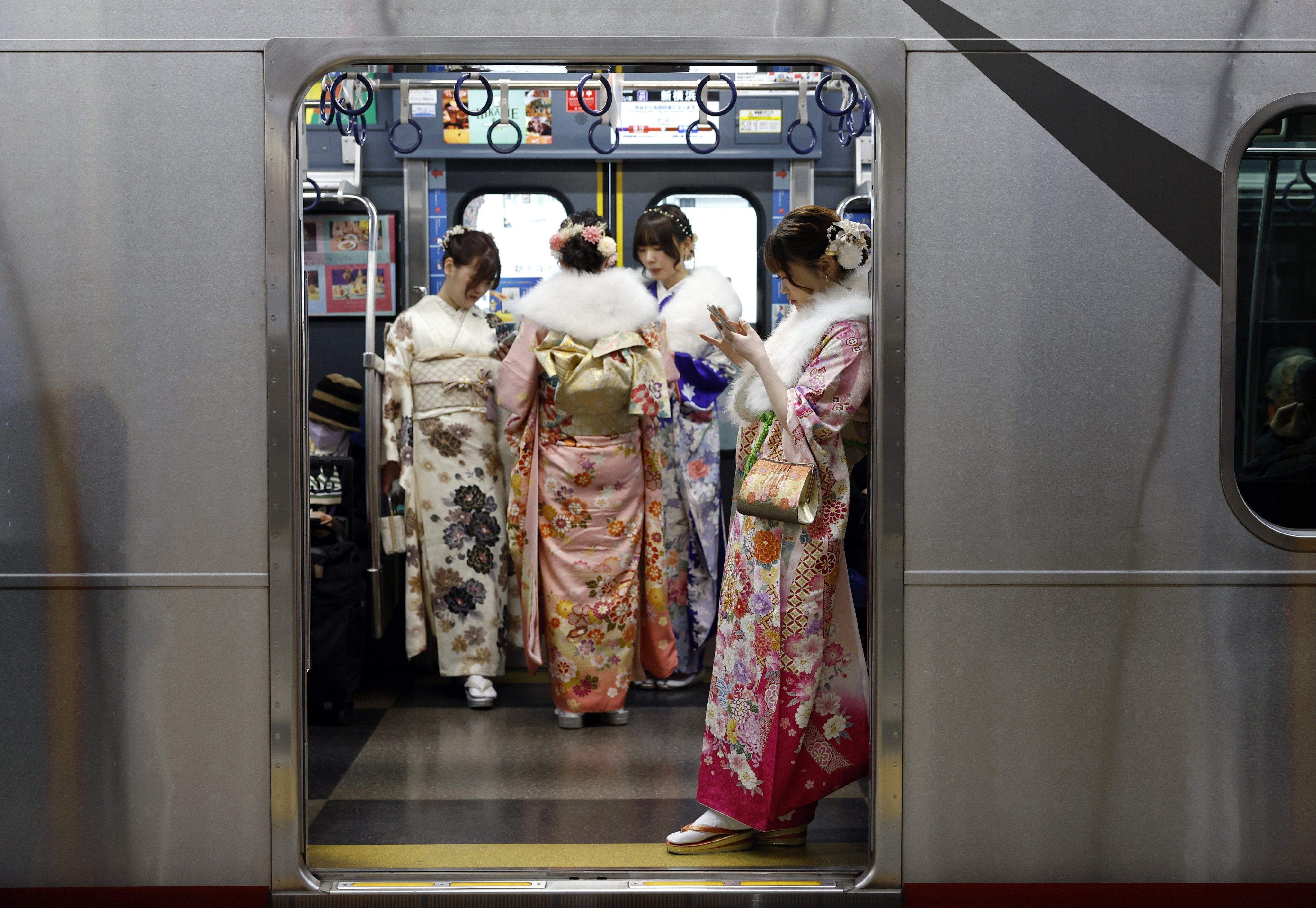 Young Japanese women wearing kimono stand in a train in Yokohama earlier this month. Photo: EPA-EFE